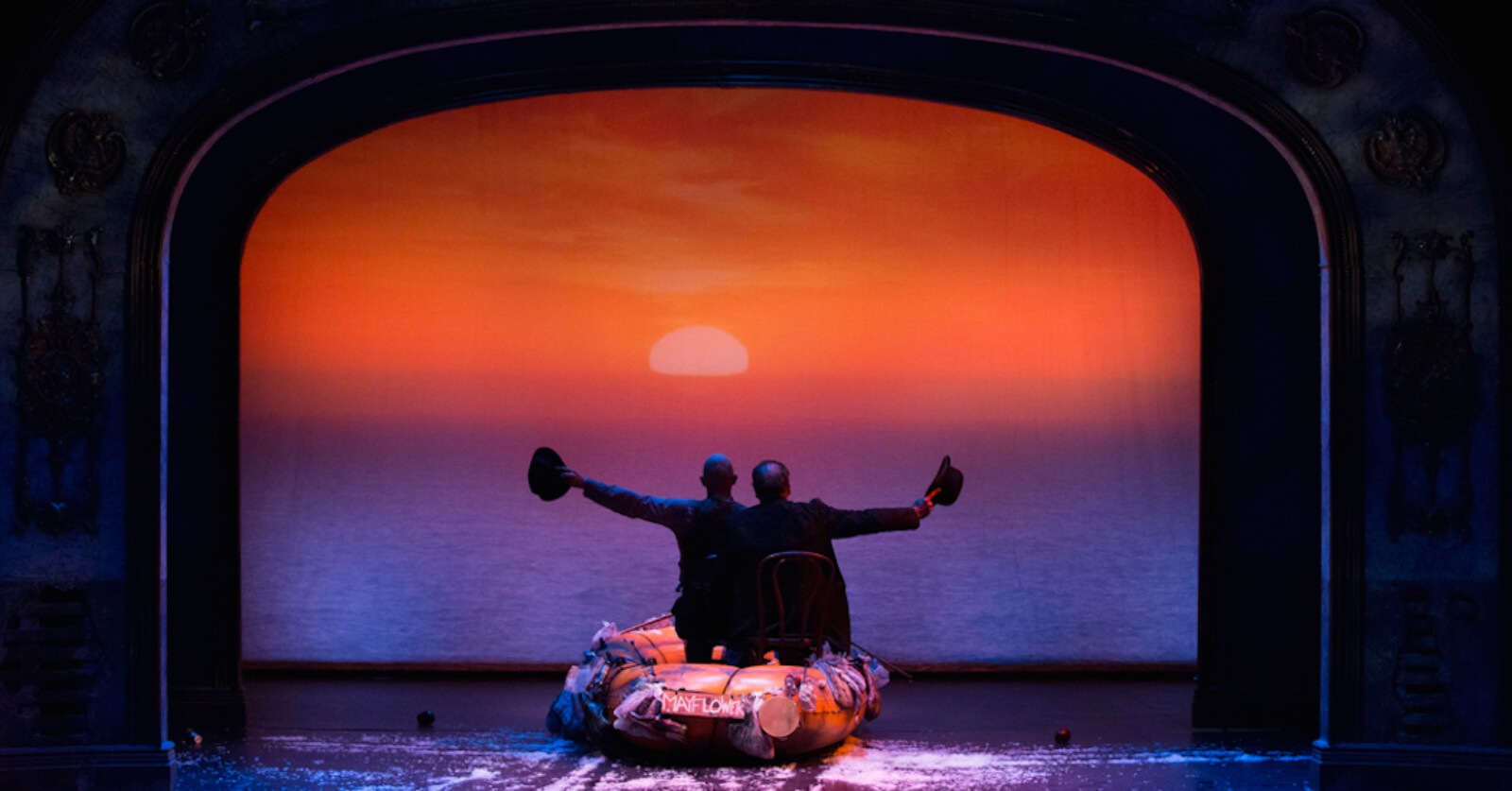 Taylor Mac and Mandy Patinkin singing "Row Row Row Your Boat" in the finale. They are in a rubber raft sailing off into the sunset, about to place their derby hats on their heads.