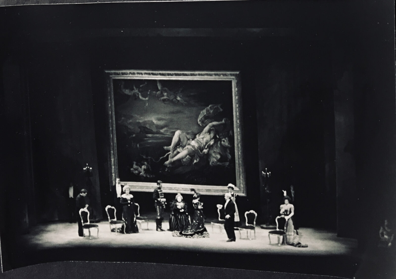 Michael Anania's set for the "Dinner Table Scene". The cast is sitting having after dinner drinks. There is a large titan painting behind them. 