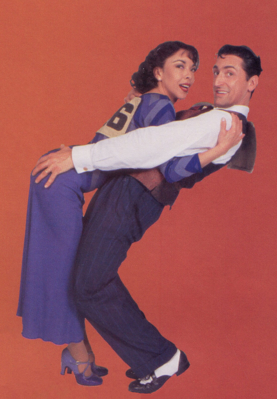 A Flying Dunlap/Couple #46 (JoAnn M. Hunter) in a matching purple outfit and Sonny (Gregory Mitchell) looking dapper in a suit, touching the former's backside, during a photoshoot.