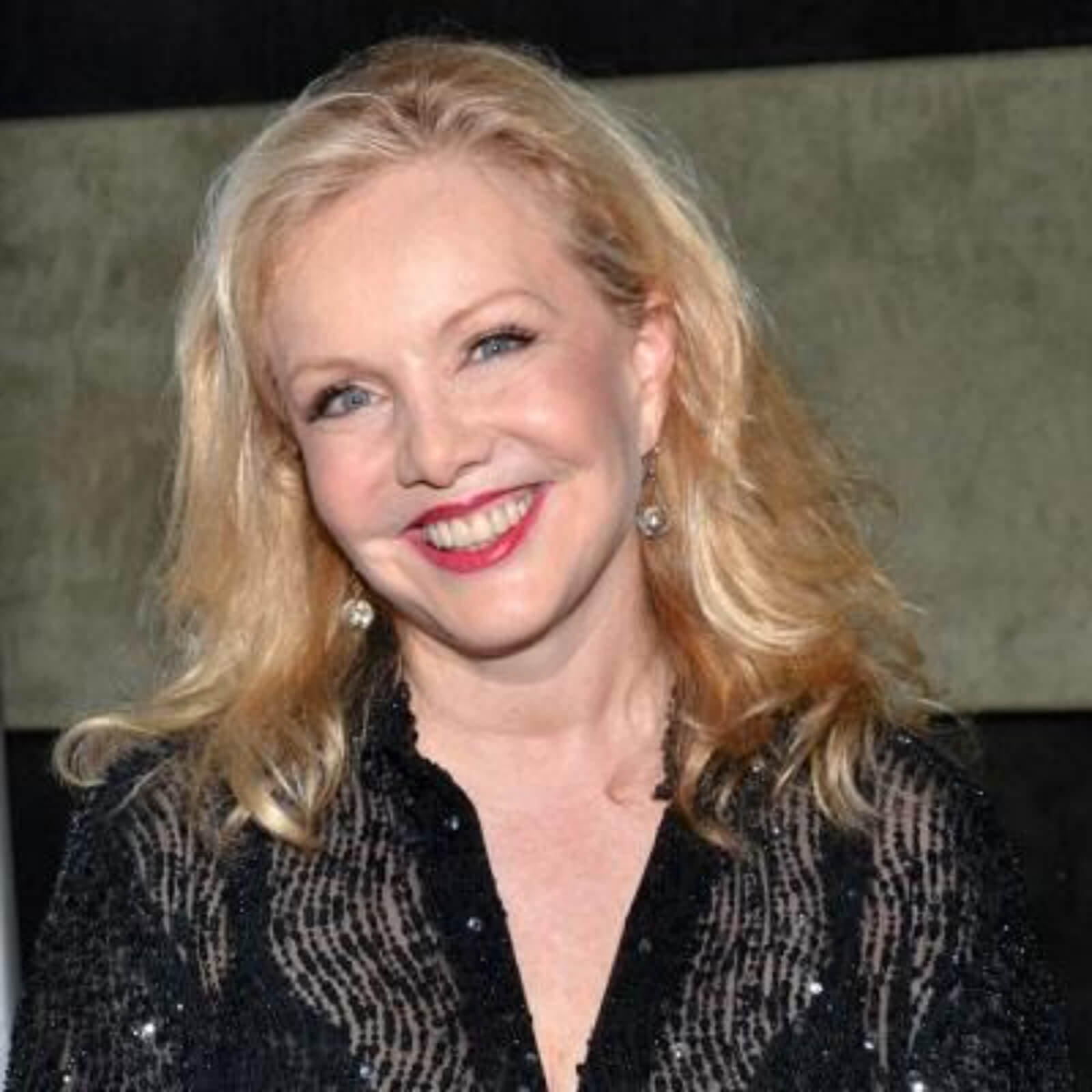 Headshot of Susan Stroman in a sparkly black shirt and beaming smile.