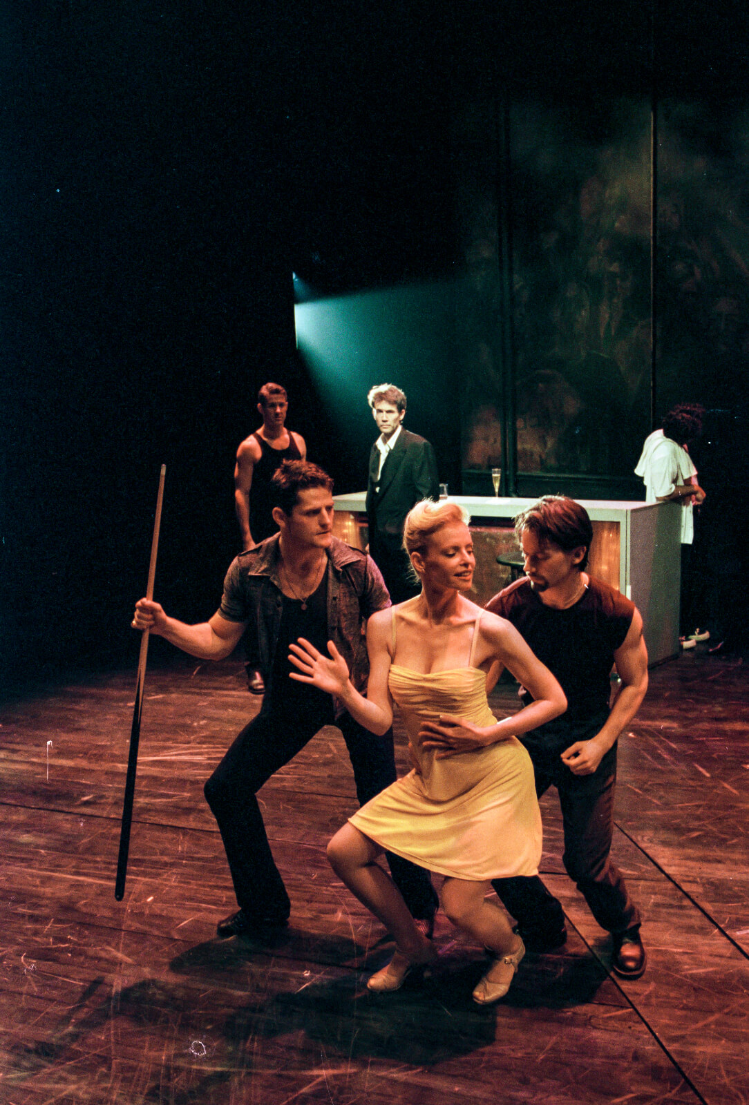 Girl in the Yellow Dress (Deborah Yates) captures the attention of club-goers, Joe (Robert Wersinger) and Johnny (Sean Martin Hingston), as they dance closely behind her.