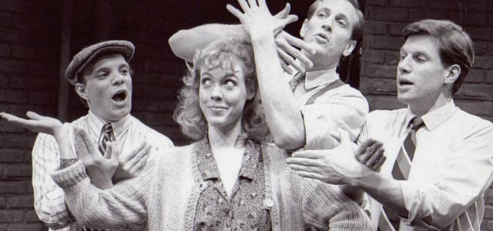 Flora (Veanne Cox) stands in the center with the boys gesturing around her in SONG