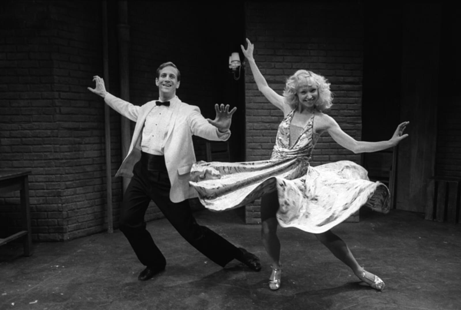 Maggie (Maggy Gorrill) and Kenny (Dirk Lumbard) lean into a pose with their arms out to their side in the dance number of "Keeping it Hot" from Flora the Red Menace.