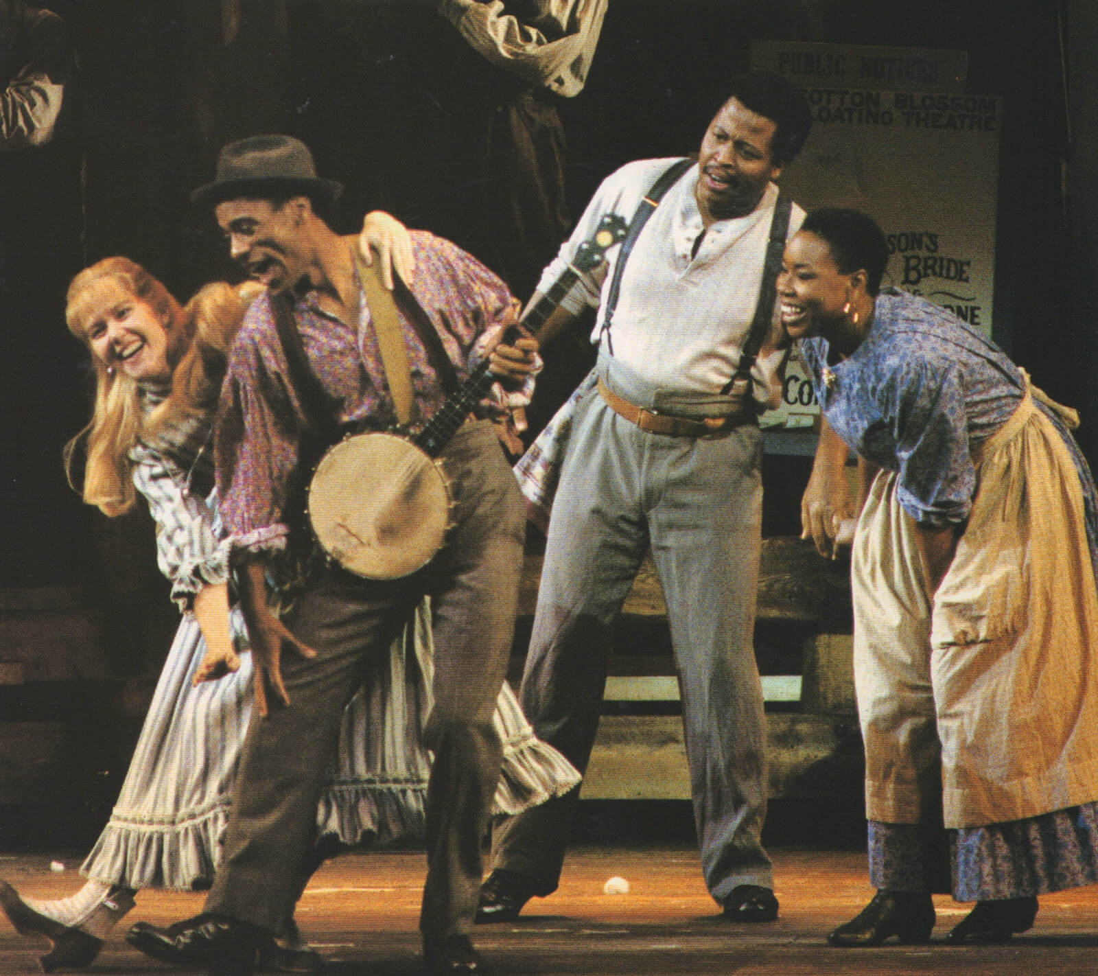 Magnolia (Rebecca Luker), in a beautiful striped blue dress, dances as an artist (in suspenders and wearing a black hat) plays the banjo. A couple behind them watch in awe.