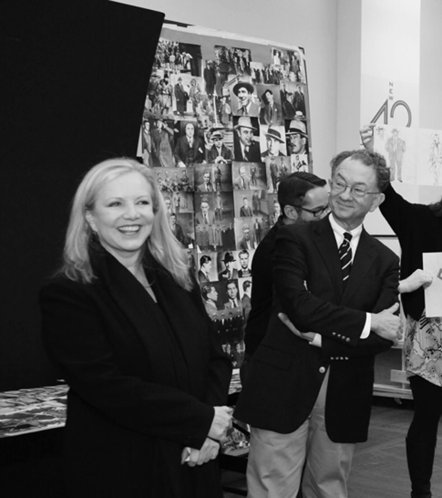 Black and white photo of Susan Stroman and costume designer William Ivey Long at a presentation for Bullets Over Broadway. Research and renderings can be seen on presentation boards.