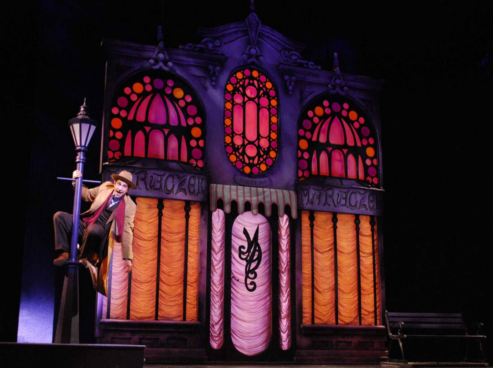 Brandon Uranowitz singing "She Loves Me". The actor dances on a lamp post in front of a colorful parfumerie in Prince of Broadway. 