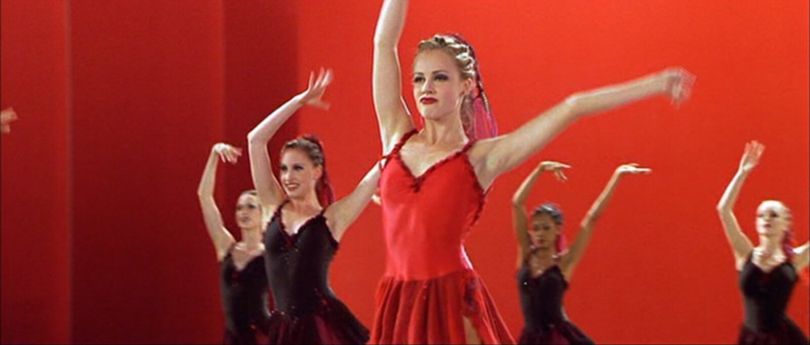 A close up of Jody Sawyer (Amanda Schull) as she stands out in a red costume for "Canned Heat" from Center Stage.