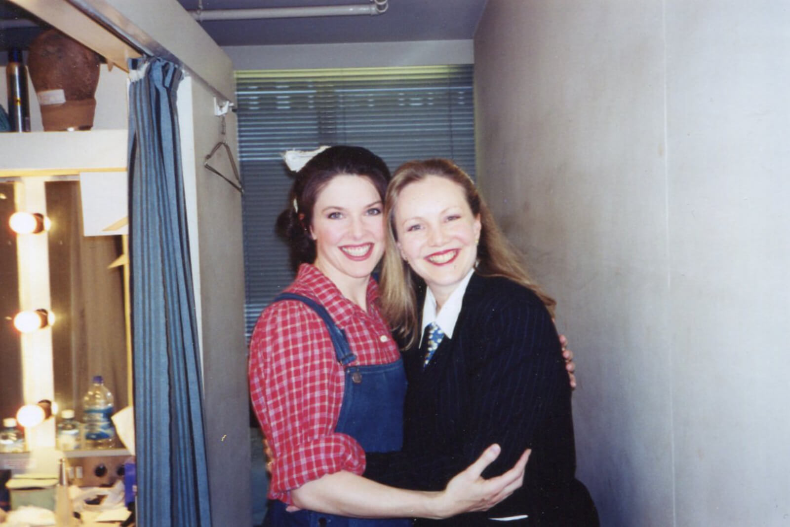 Susan Stroman in her all-black outfit with white collar, and Laurey Williams (Josefina Gabrielle) in the dressing/powder room backstage, smiling for the camera.