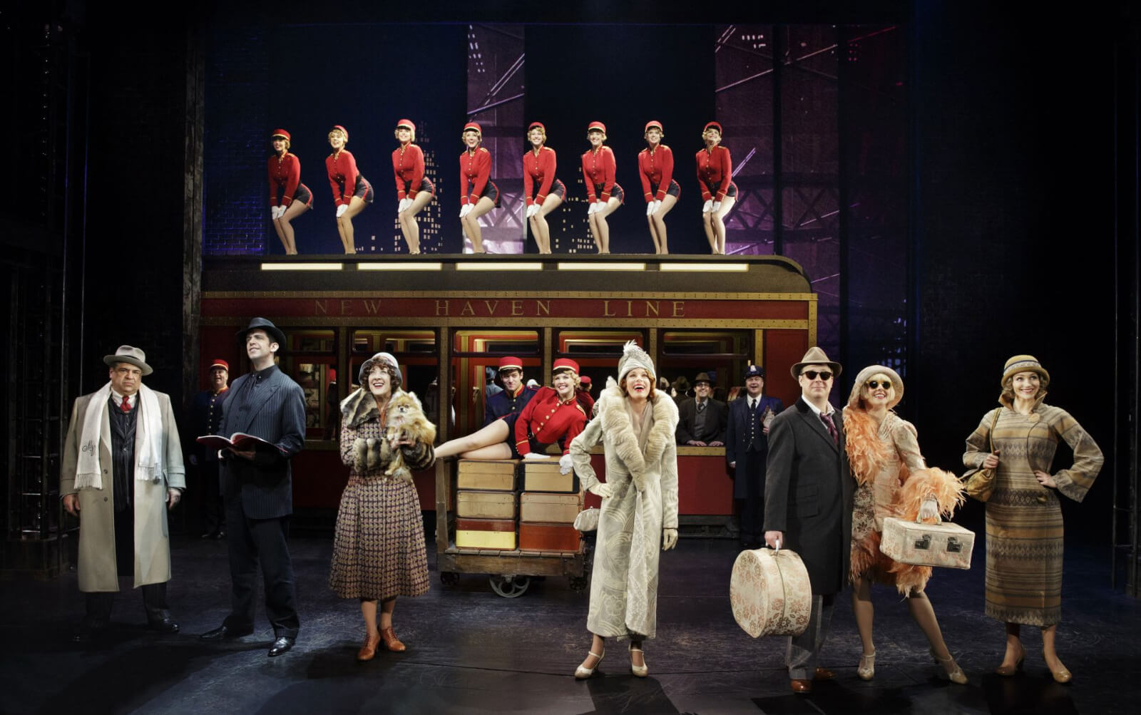 The company in the Act One finale: usherettes on top of a New Haven Line train and all dressed for travel.