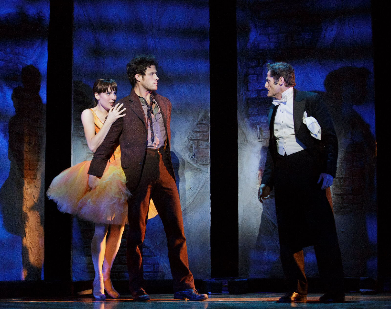 Marie (Tiler Peck) being protected by Christian (Kyle Harris) as Philippe (Seán Martin Hingston) threatens them in the musical Little Dancer.