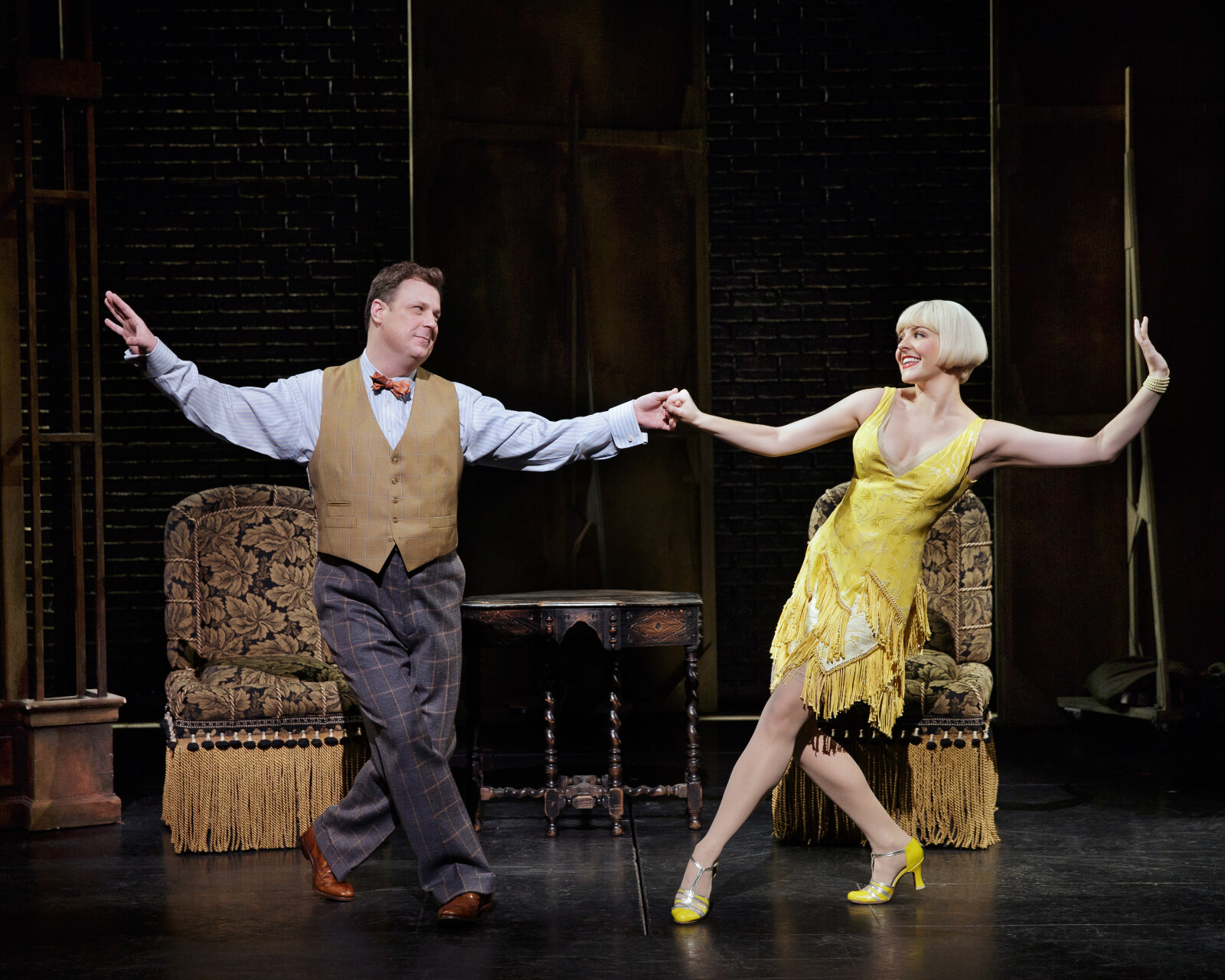 Warner Purcell (Brooks Ashmanskas in a bow tie and vest) dancing with Olive Neal (Heléne Yorke in a yellow dress).