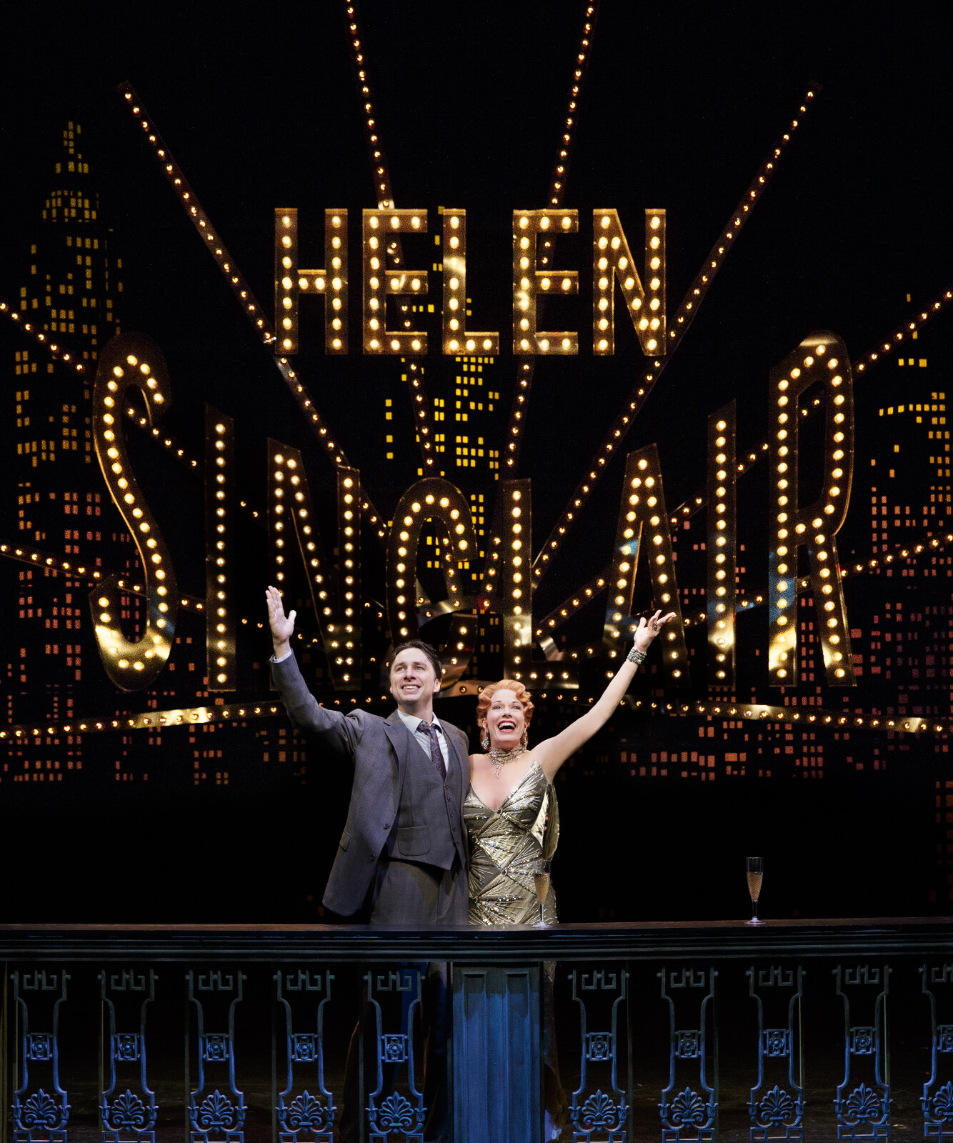 David Shayne (Zach Braff) and Helen Sinclair (Marin Mazzie) with arms raised in front of the lit marquee of "Helen Sinclair" spelled in lights.