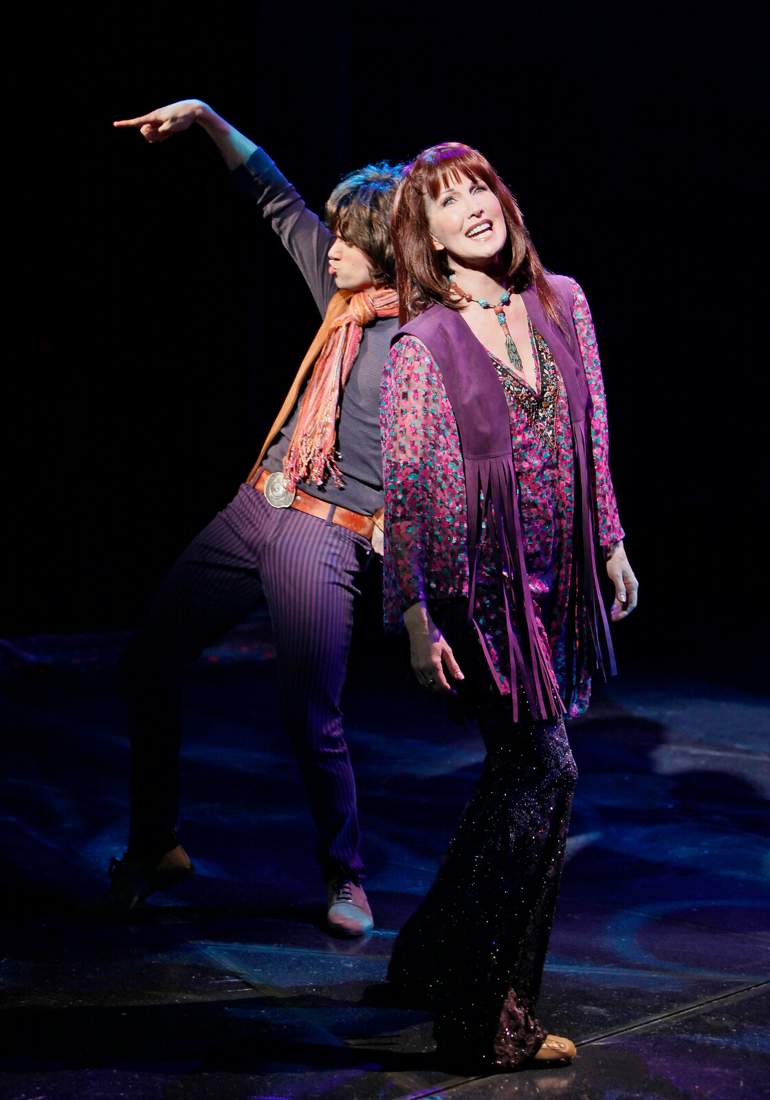 Mick Jagger (Robb Sapp) with Arlene (Joanna Gleason) singing "Road to Nirvana". Both are dressed in 70's era clothing.