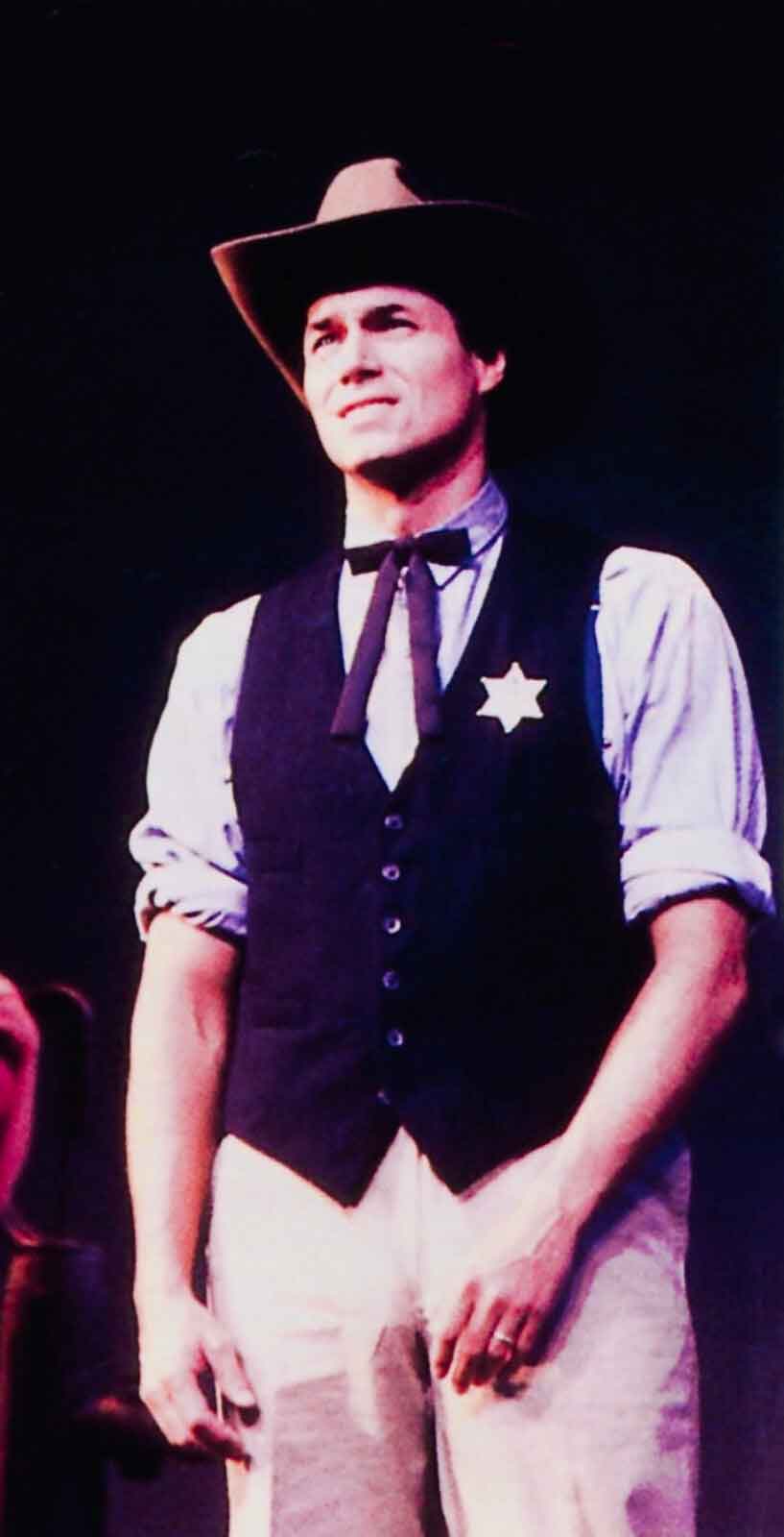Richard Muenz (dressed as a Sheriff with a cowboy hat, western tie, and vest) from the New York City Opera Production of 110 in the Shade.
