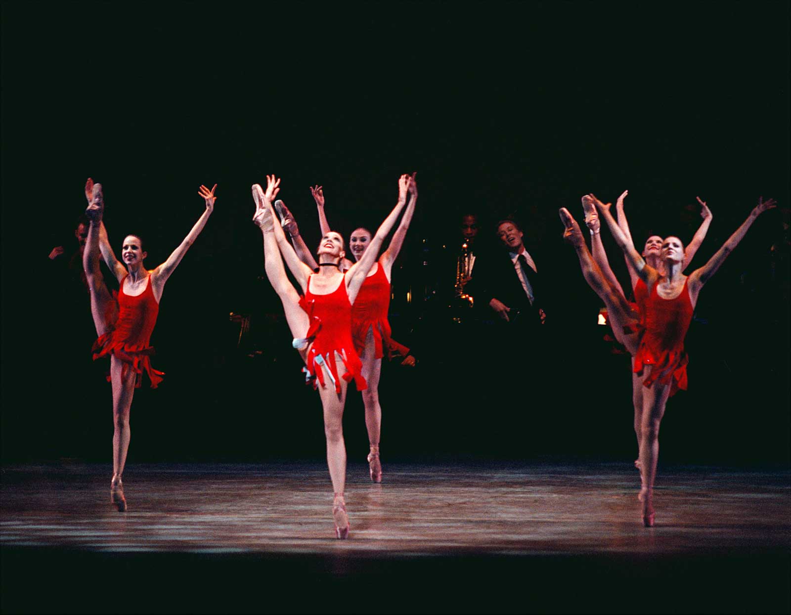 Dancers in "It Don't Mean a Thing if it Ain't Got That Swing". They all have their right leg in Grande Battement dressed in red flapper costumes.