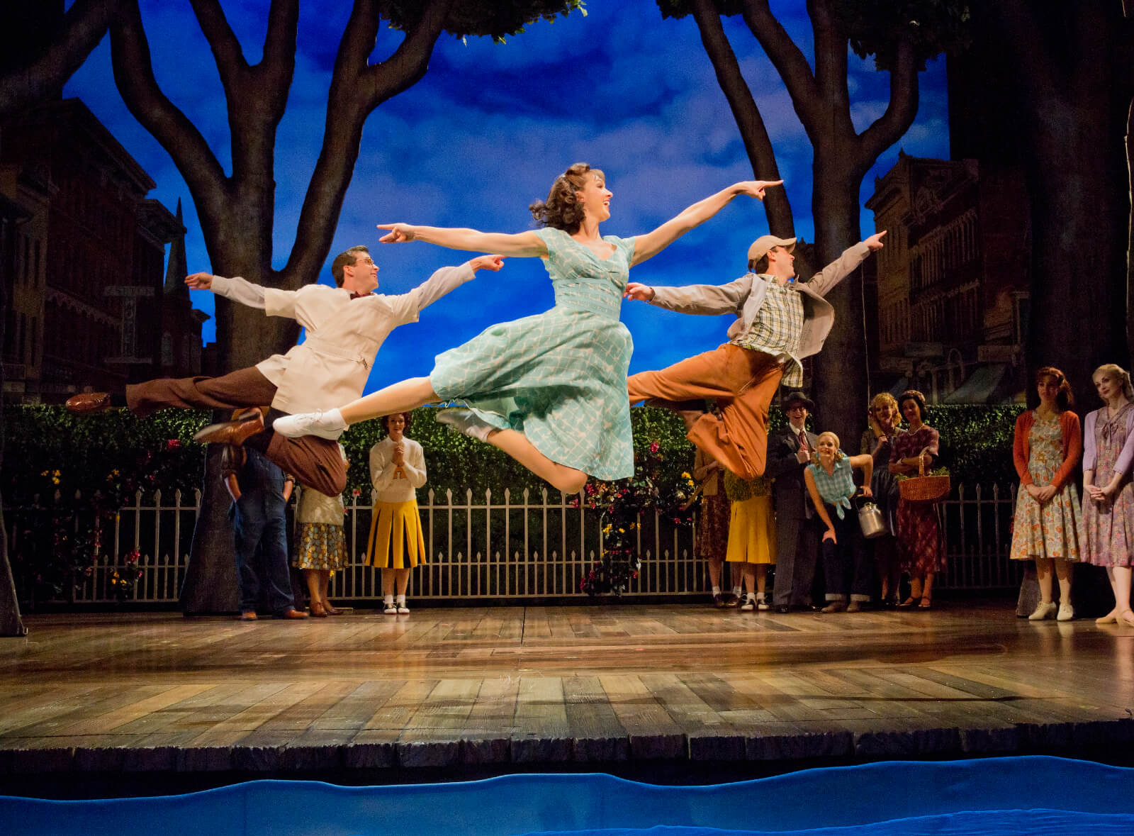 Jason Lee Garrett, Lara Seibert Young, and Cary Tedder performing "Out There on the Road". The trio leaps in unison onstage. 