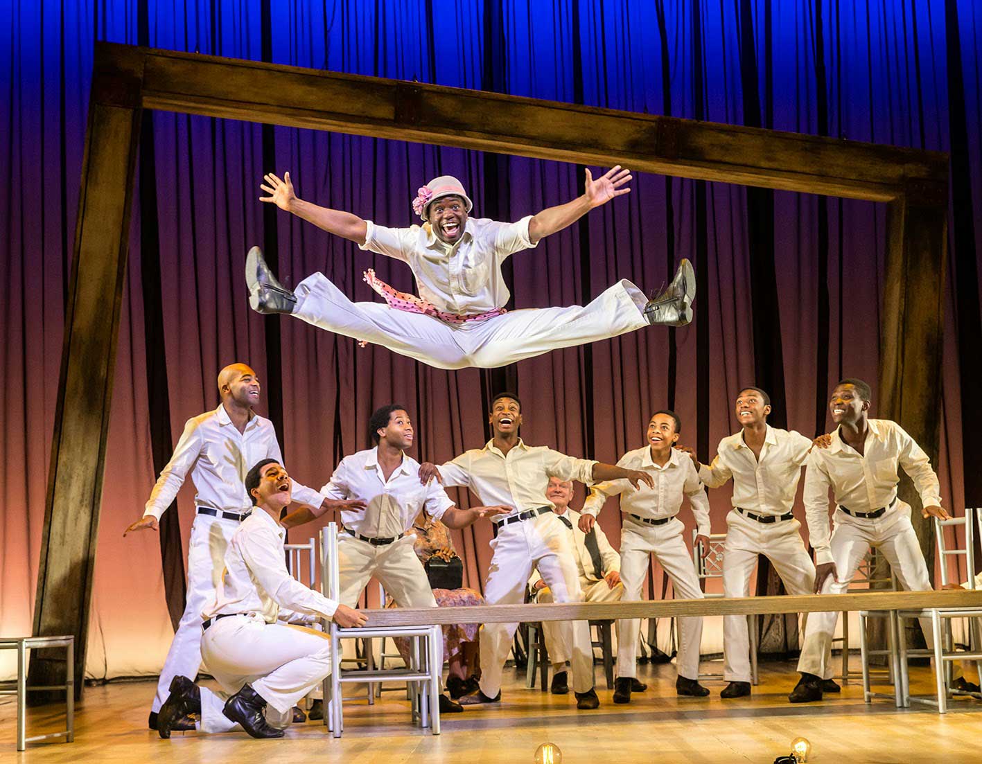 James T. Lane as Ruby Bates does a show-stopping jump in second. The other Scottsboro Boys cheer Ruby on.