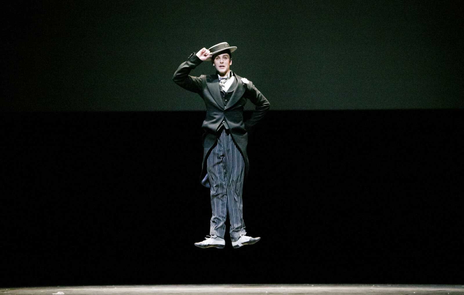 Tom Gold in a jump in the air with his feet in first position. 