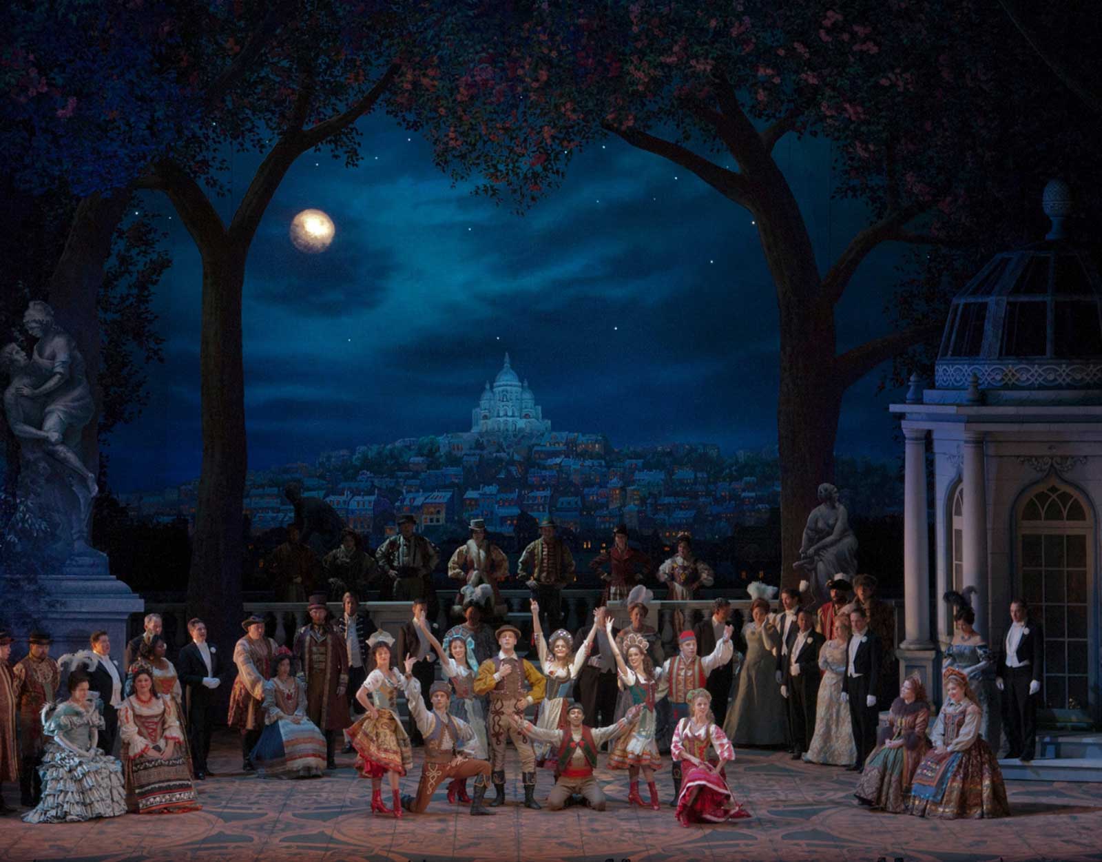 The cast performs a Pontevedrian Folk Dance in Hanna's Garden. There are in traditional kolo dance costumes. There is a view of Paris in the background. There is a full moon. 
