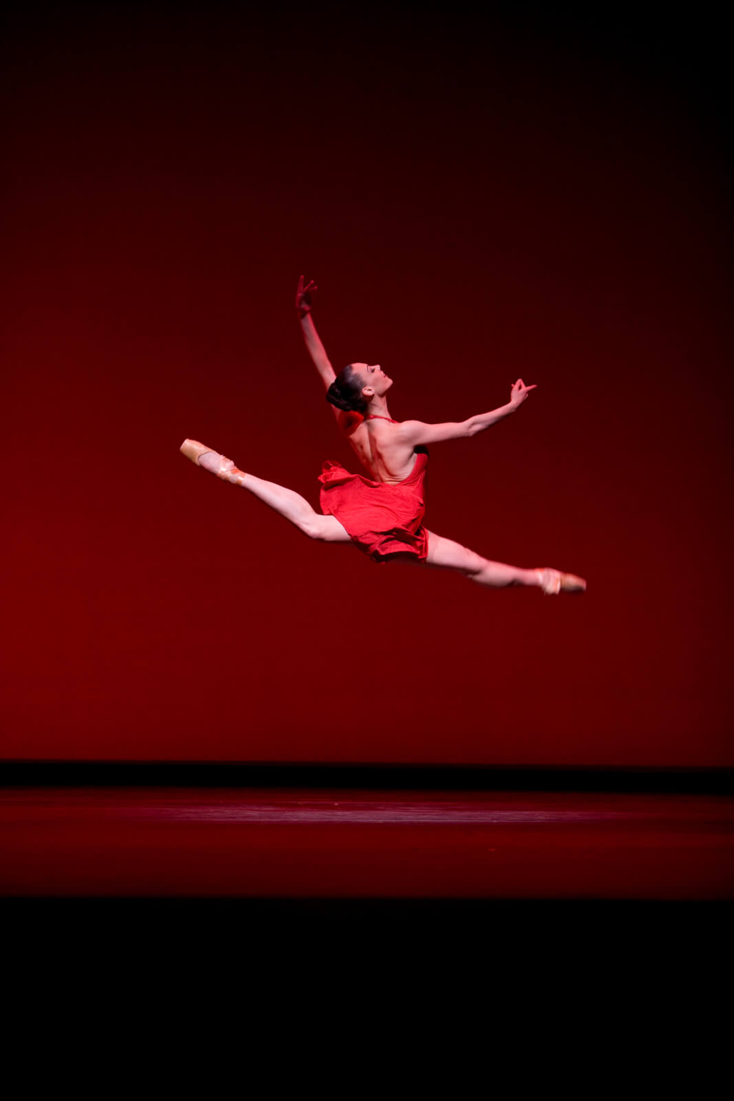 Kari Brunson as Red in a jete - flying through the air.