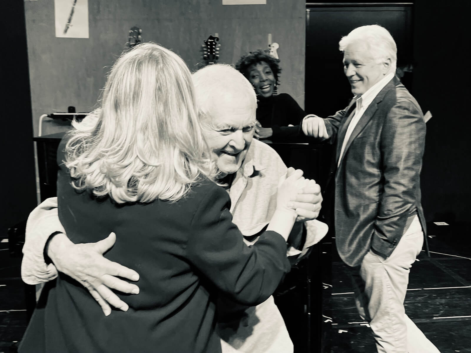 Black and white photo of Susan Stroman and John Kander dancing during the New York, New York workshop. Writers Sharon Washington and David Thompson are in the background smiling.