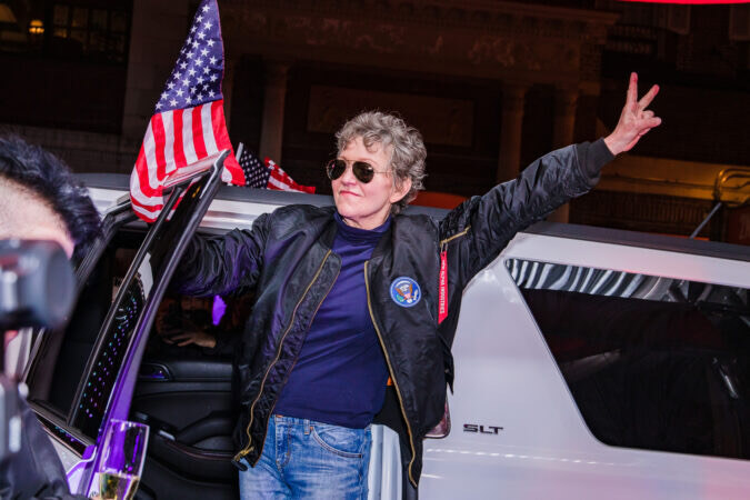 First preview with cast member Julie White, exiting a limo with peace sign on hand, aviator glasses, and bomber jacked. Limo is sporting an American flag.