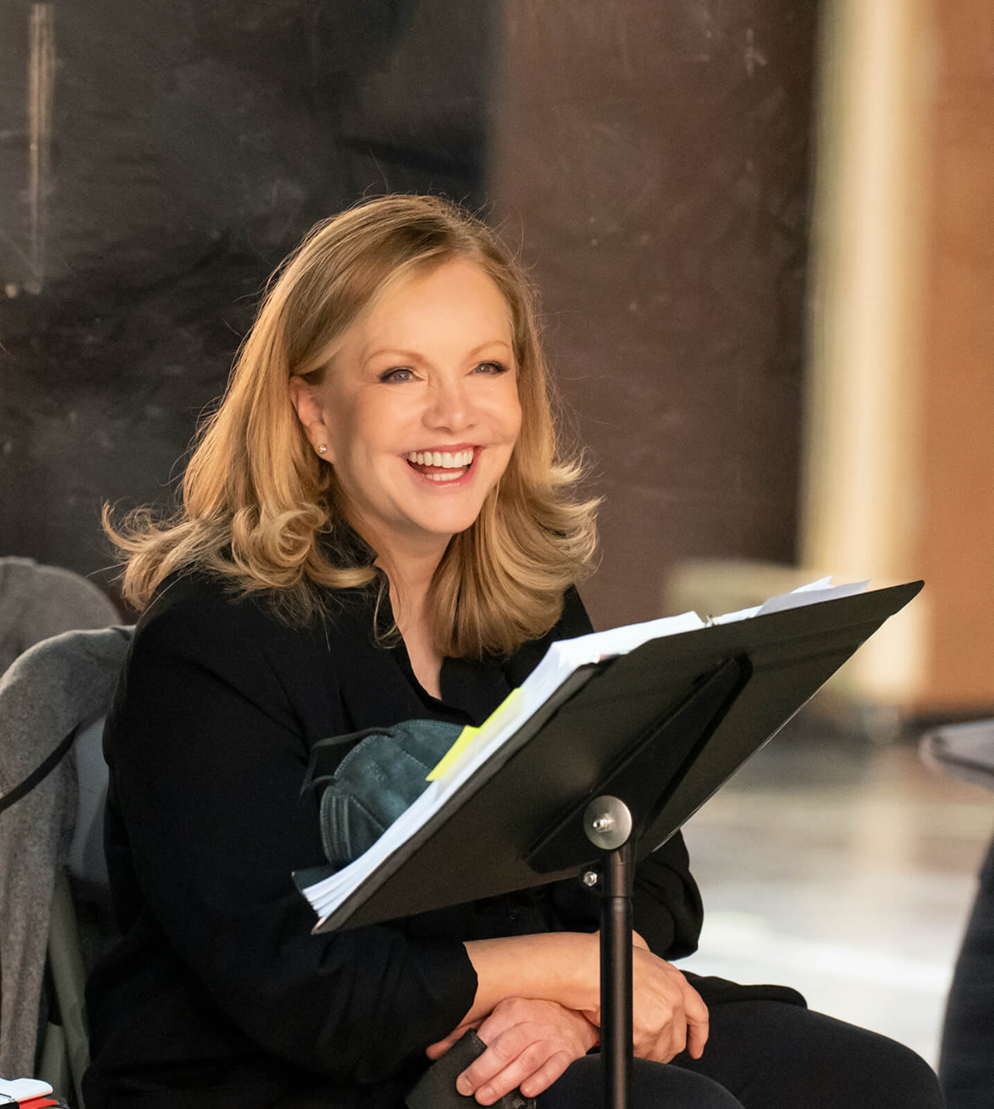 Director and Choreographer Susan Stroman behind a music stand smiling while in rehearsal for New York, New York: A New Musical.