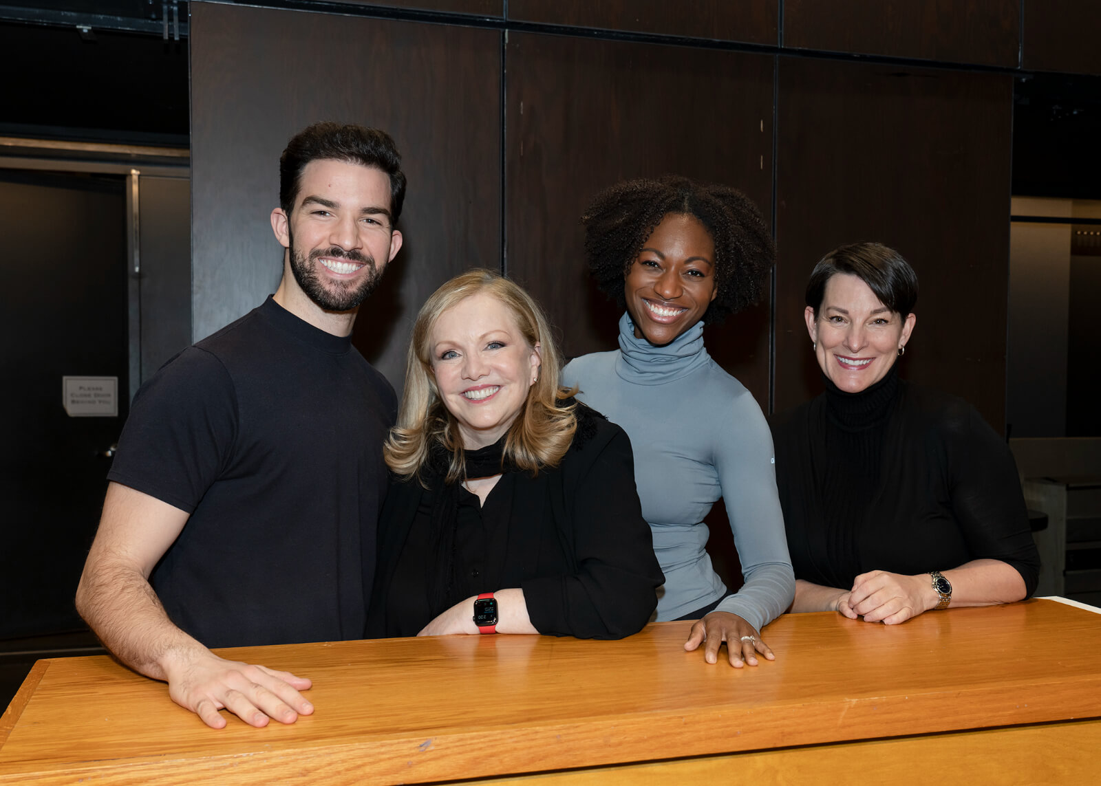 Director Susan Stroman with Associates Phil Colgan, Jenny Laroche and Tara Young standing behind a piano in rehearsal.