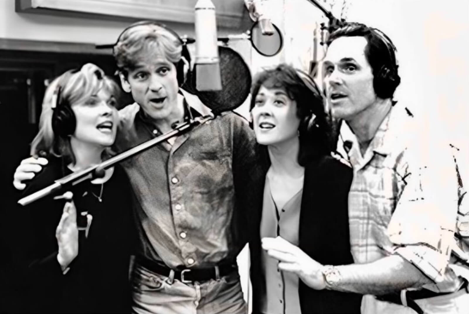 Debra Monk, Daniel McDonald, Karen Ziemba, Gregory Harrison singing “Steel Pier” from the Broadway musical. They are in the recording studio surrounding a microphone.