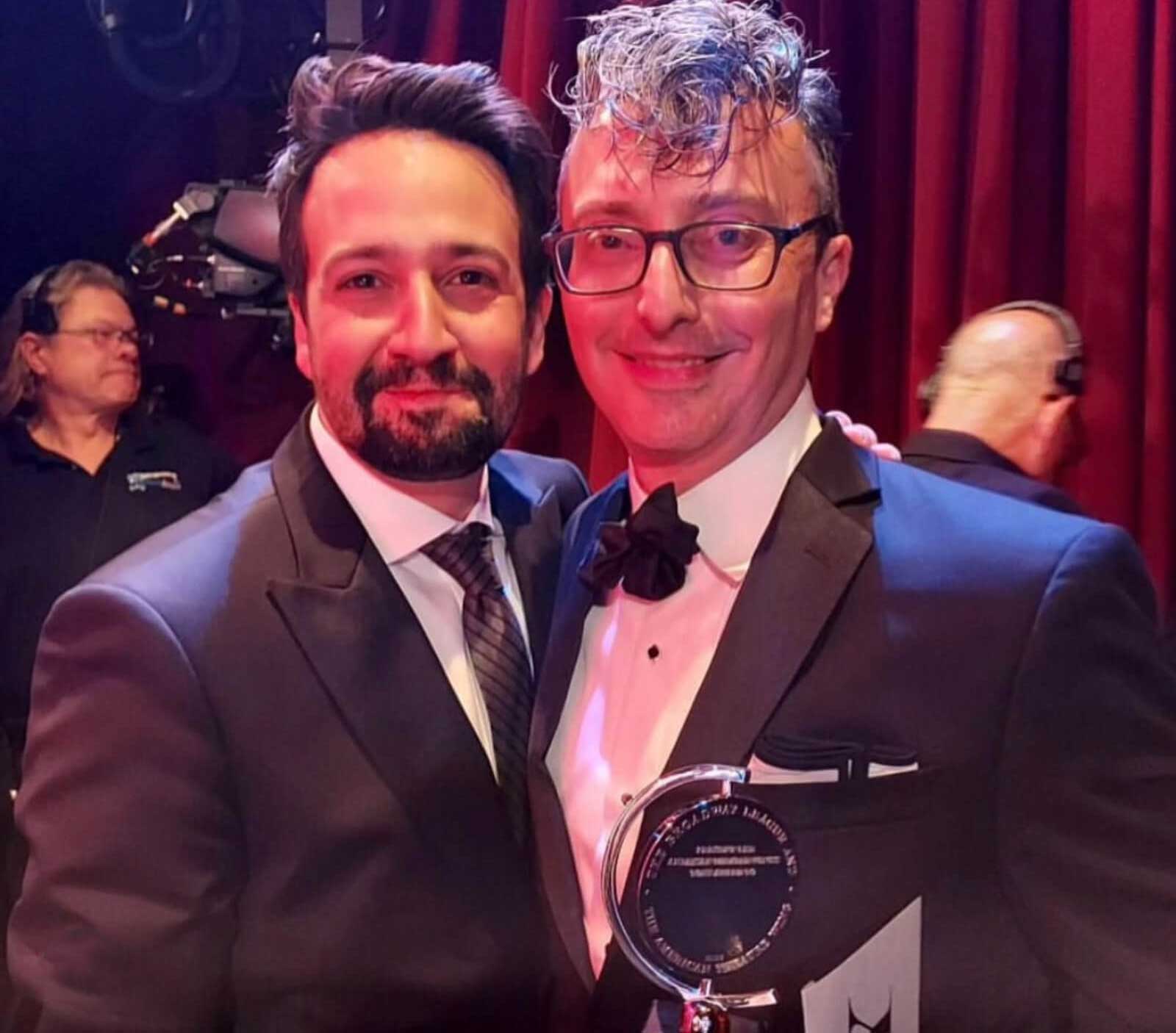 Lin-Manuel Miranda hugs set designer Beowulf Boritt on Tony Award Night. Both are in black tie and Beowulf holds his latest award.