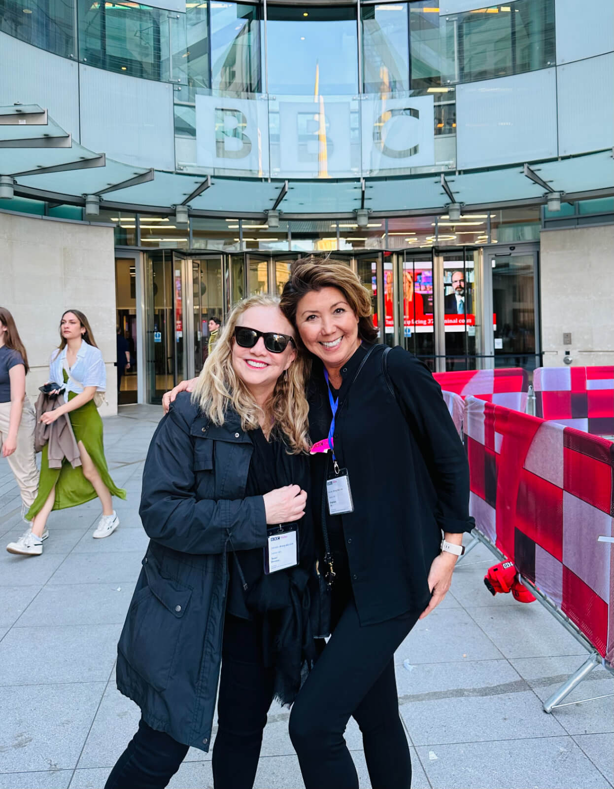Director/Choreographer Susan Stroman and Associate Director & Choreographer Angelique Ilo hugging in front of the BBC Headquarters. 