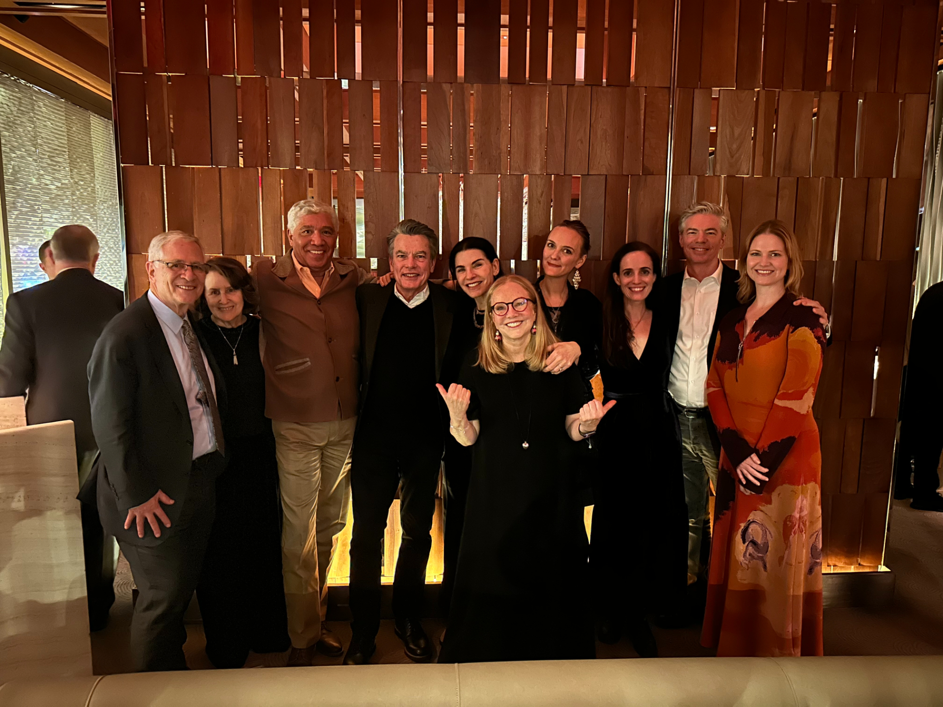 Susan Stroman with the full company of Left on Tenth. They are all standing together in a nice restaurant. 