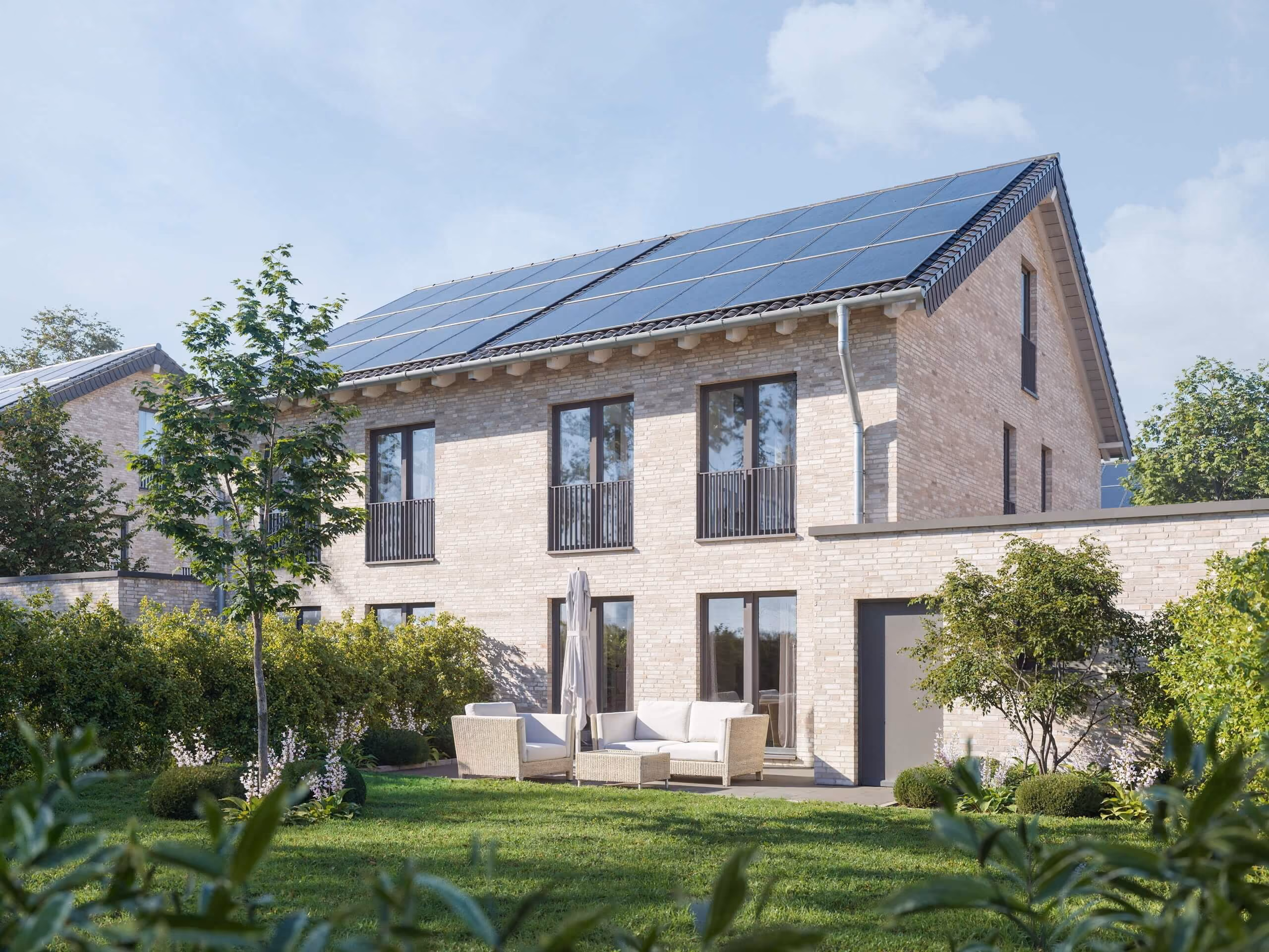 Modernes Haus mit Solarpaneelen, Terrasse mit Sitzmöbeln und gepflegtem Garten.