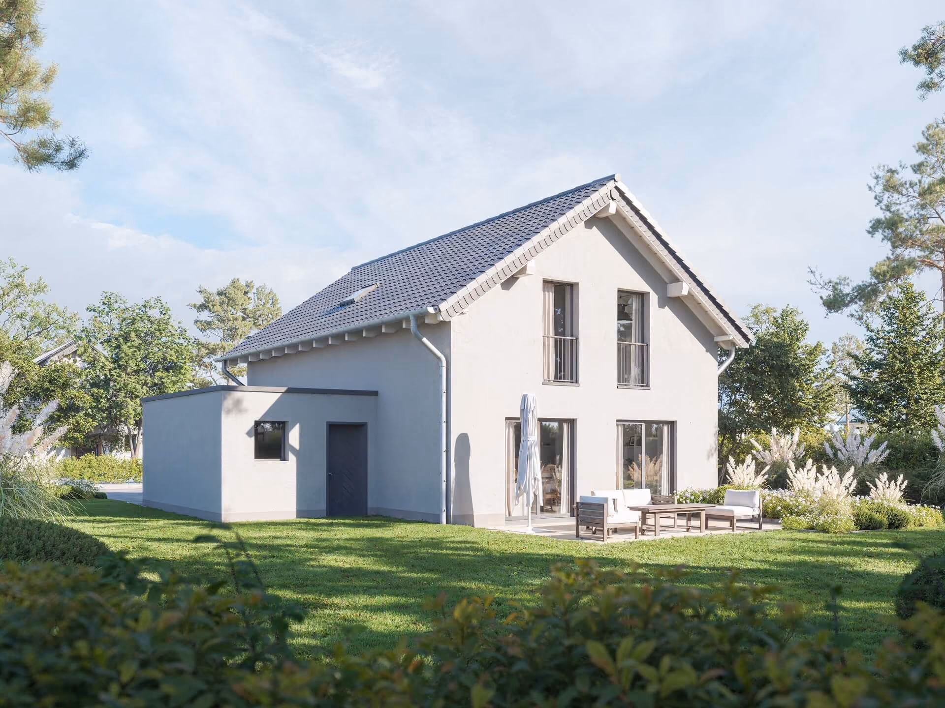 Modernes weißes Haus mit schwarzem Dach und Gartenmöbeln auf grünem Rasen mit Bäumen.