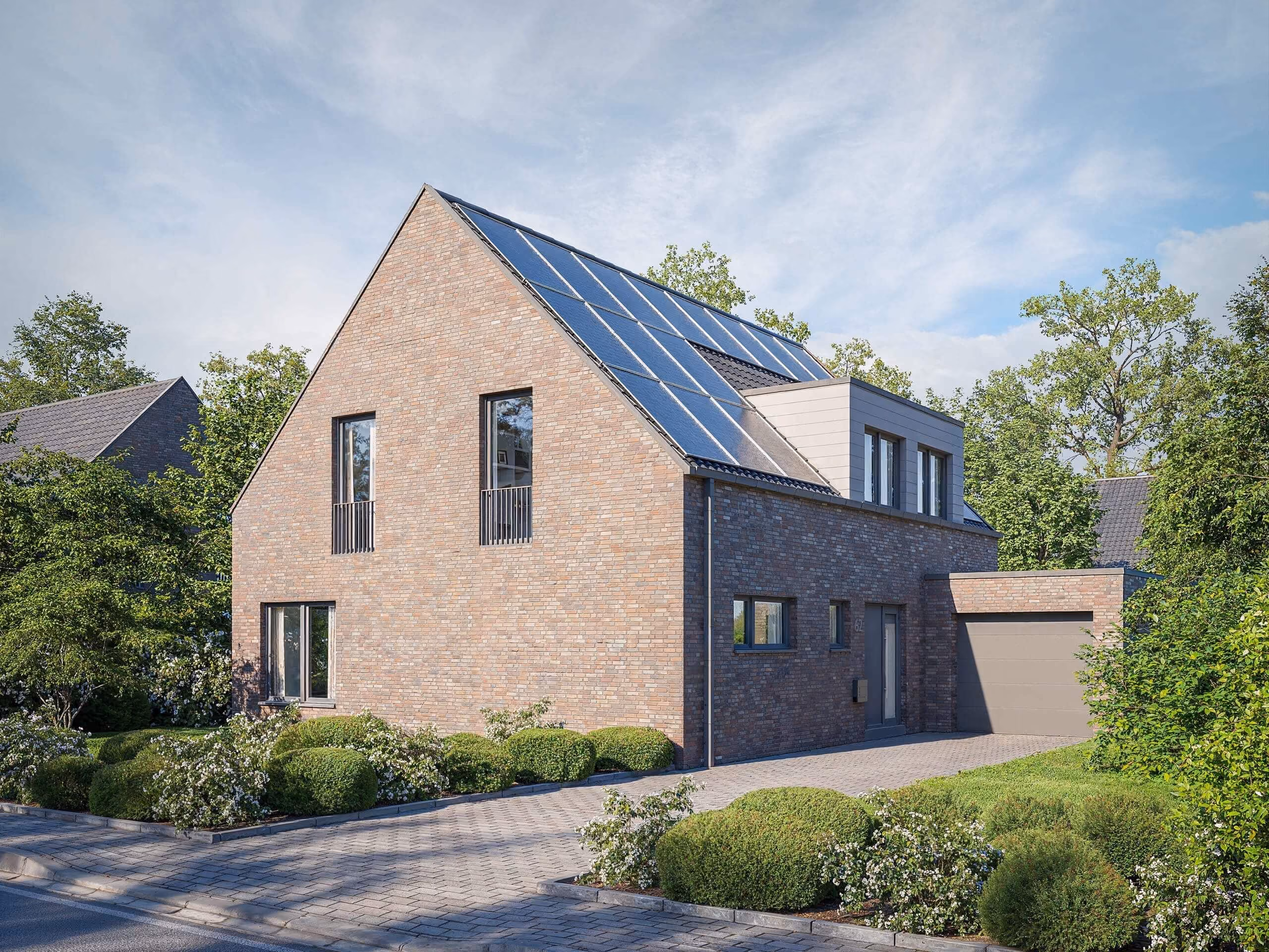 Modernes Einfamilienhaus mit Solarzellen auf dem Dach und gepflegtem Garten an einer Straße.