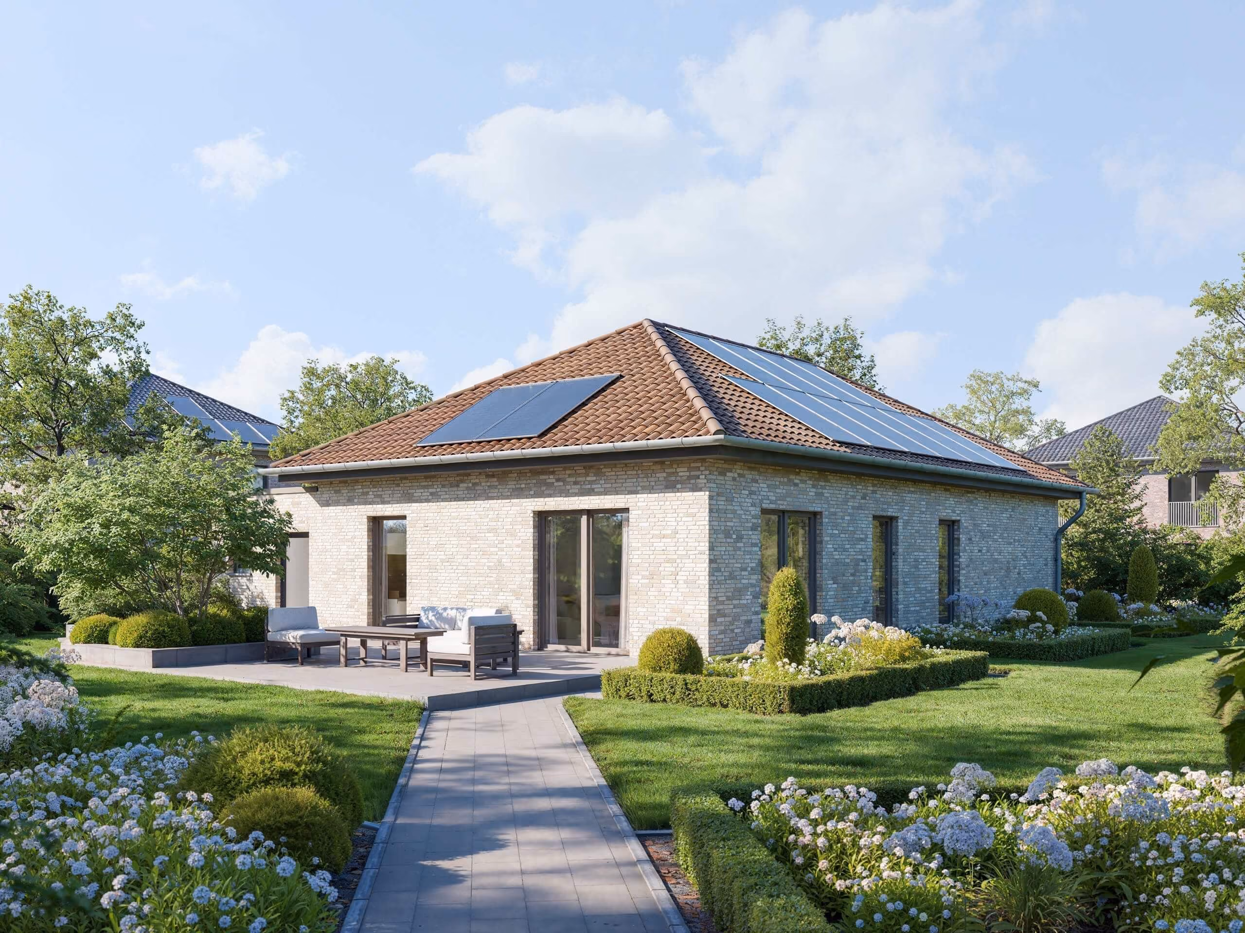 Modernes Haus mit Solarpaneelen, Terrasse und schön gepflegtem Garten mit grünen Büschen und Blumen.