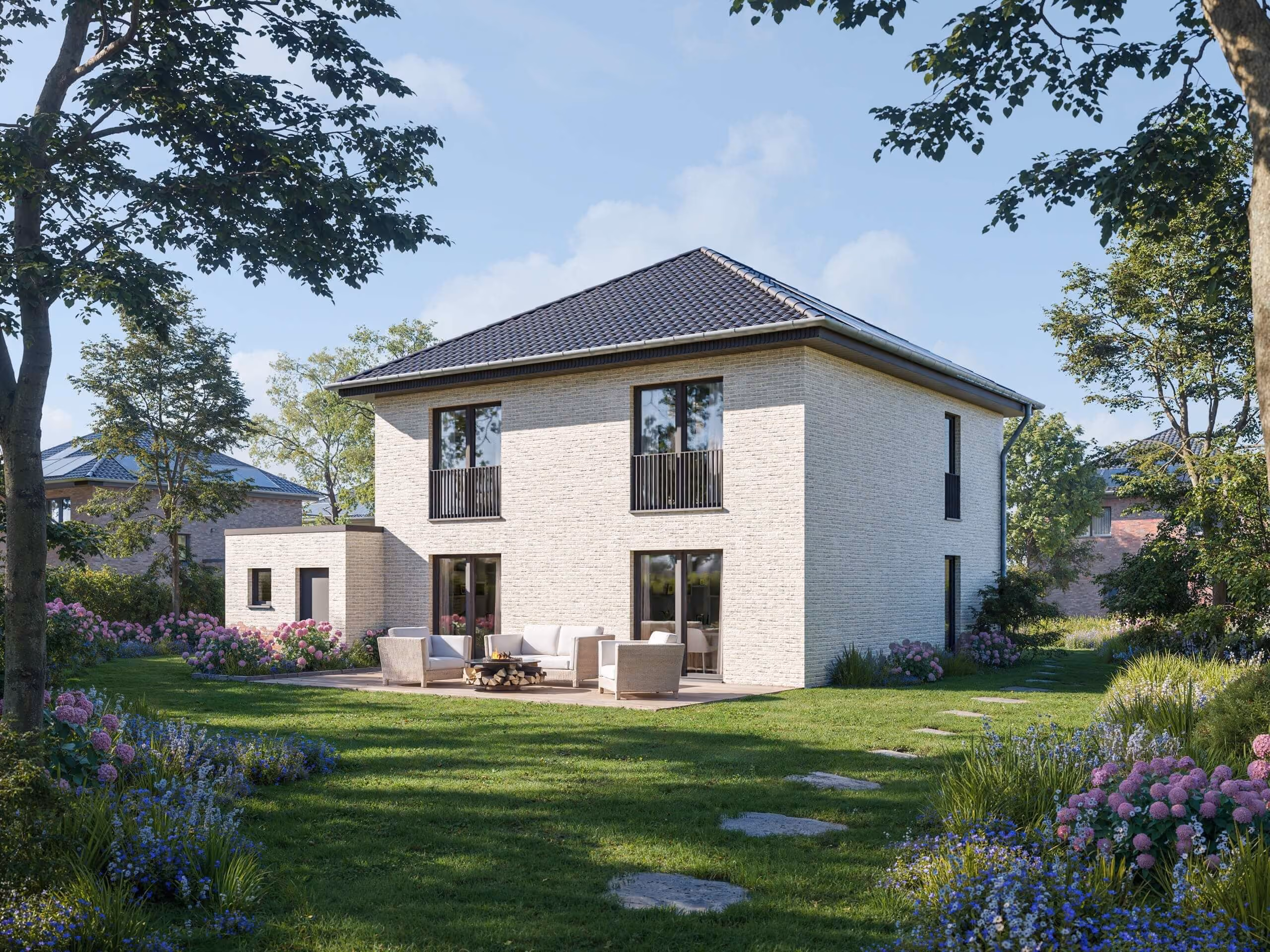 Modern zweistöckiges Haus mit Terrasse, Gartenmöbeln, umgeben von grünem Rasen und bunten Blumen.