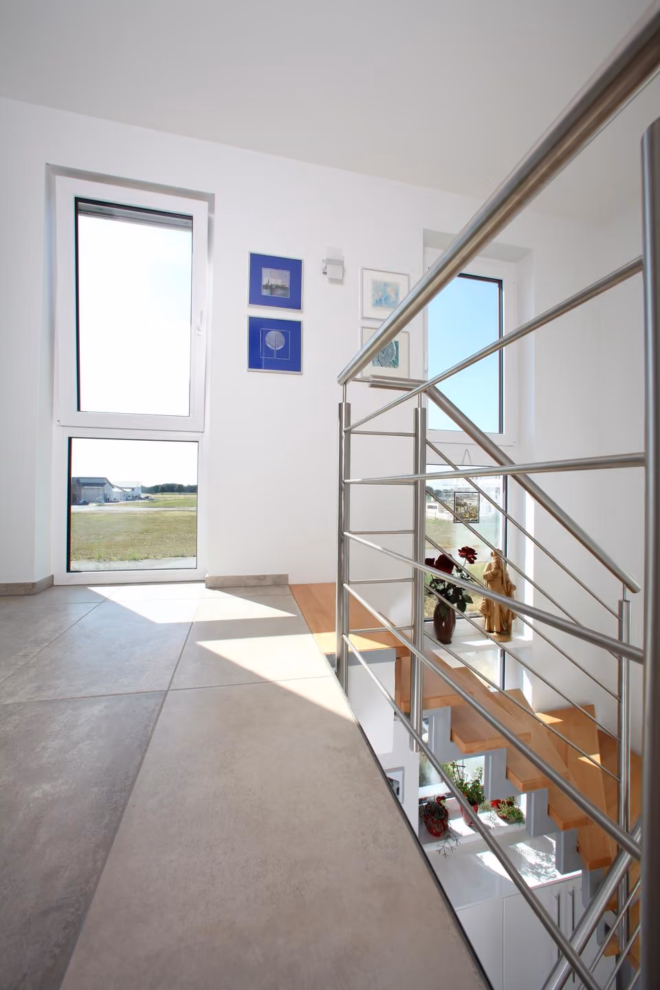 Galerie im Obergeschoss mit Geländer und hohem Fenster