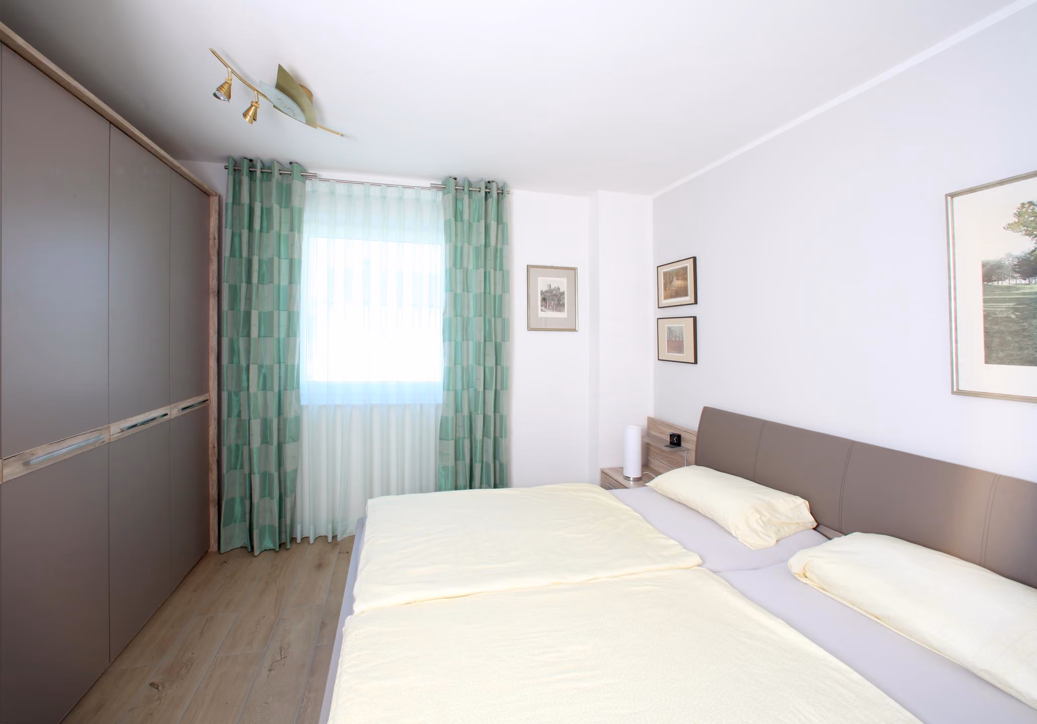 Schlafzimmer mit hellem Bett und Fenster