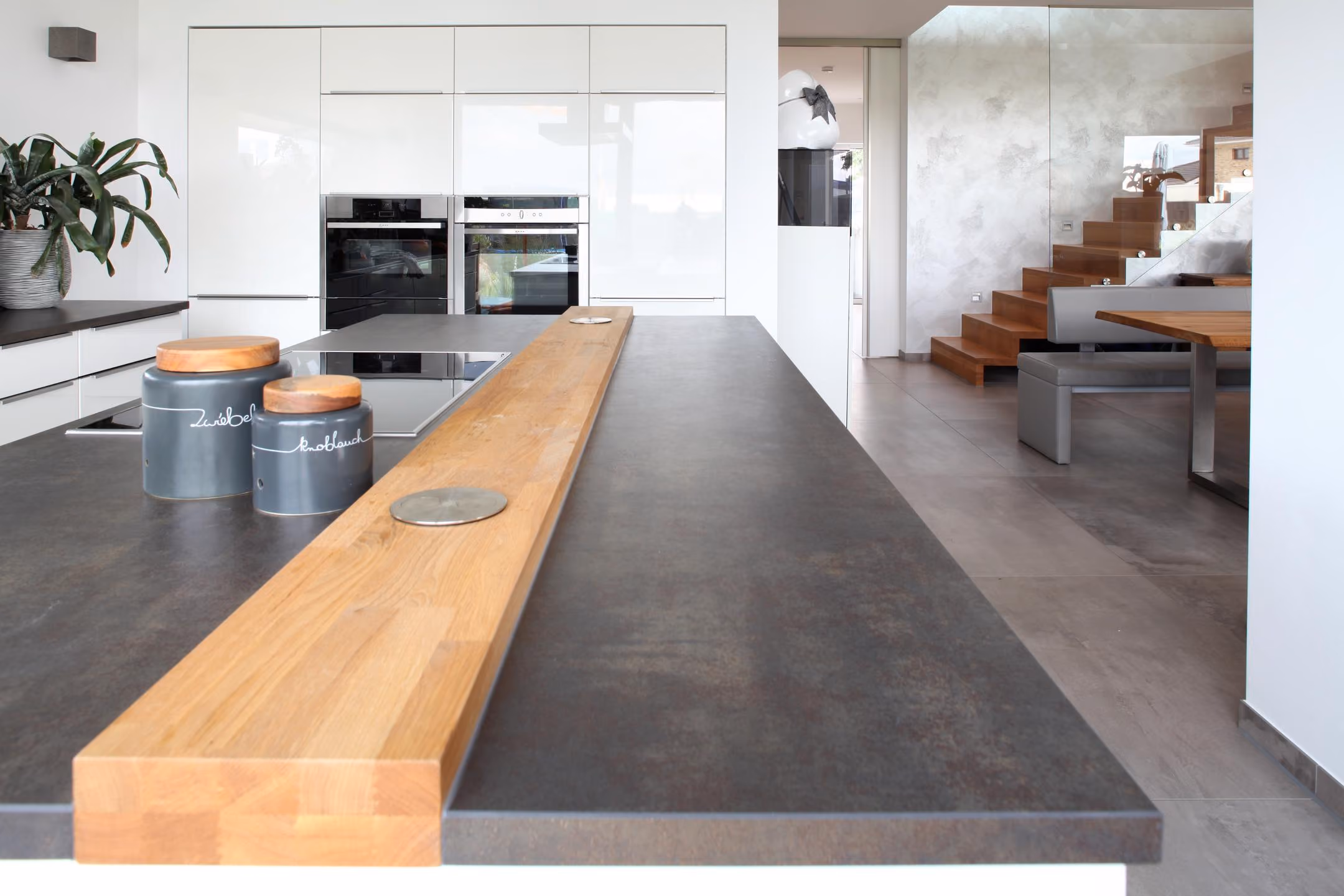 Kochinsel mit Theke aus Holz und Blick zur Treppe