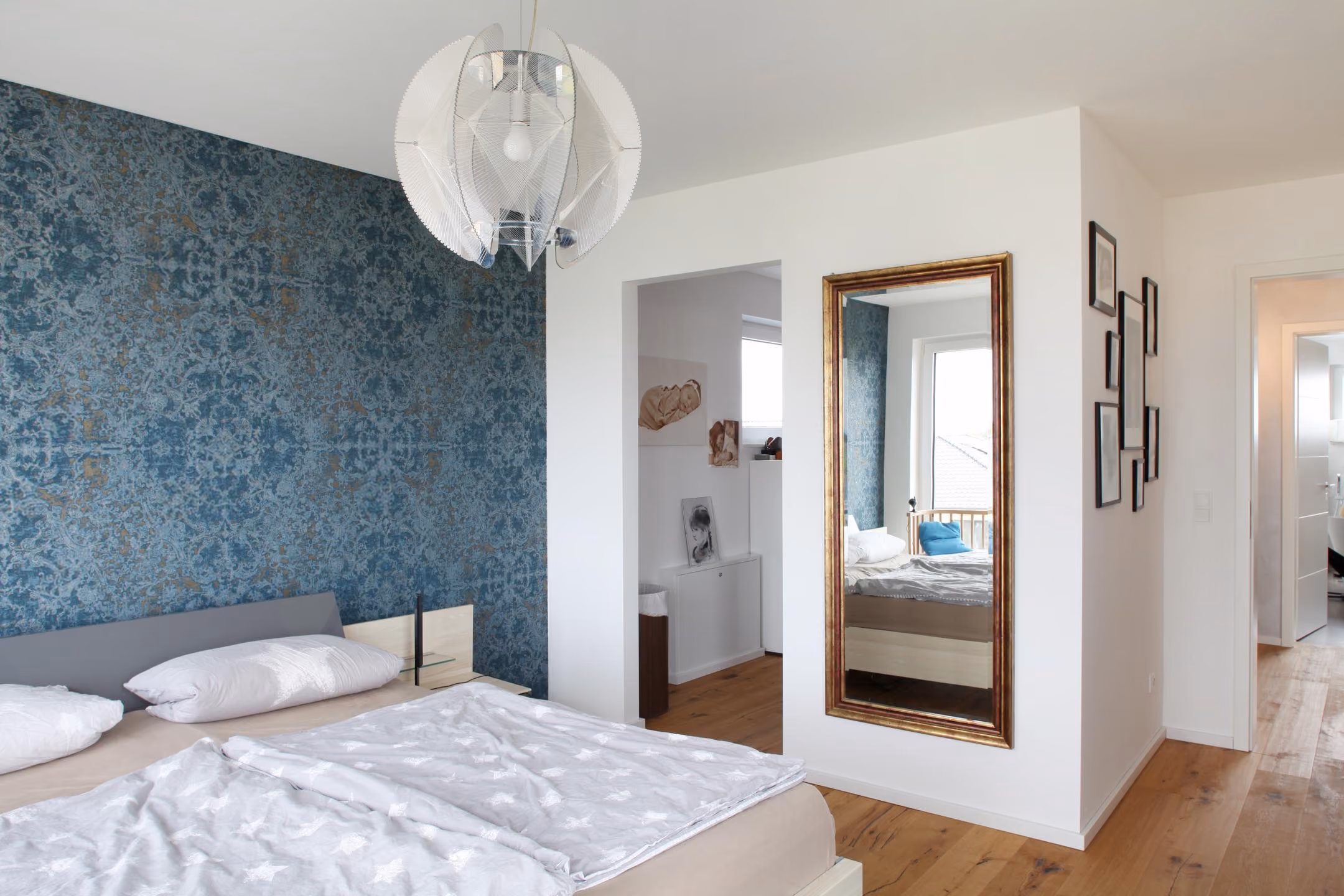 Schlafzimmer mit gemusterter Tapete und Standspiegel
