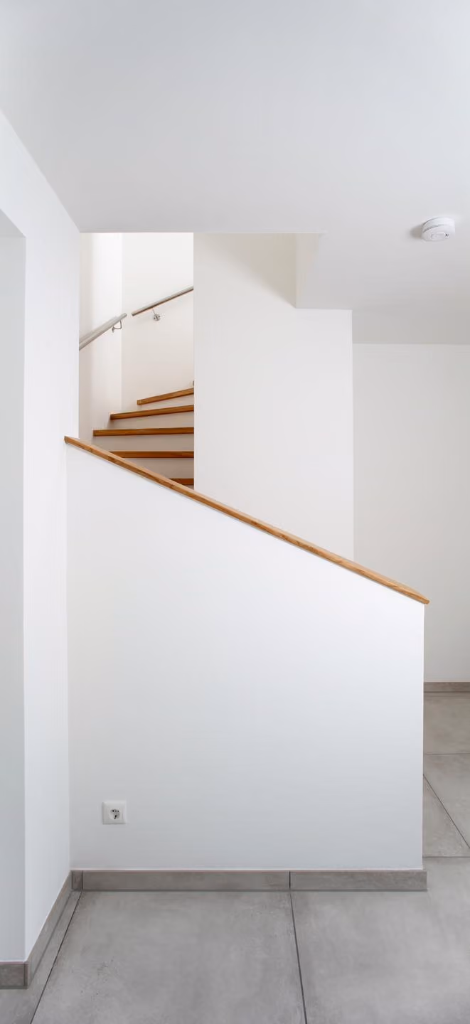 Treppe mit Holzstufen und weißer Wange