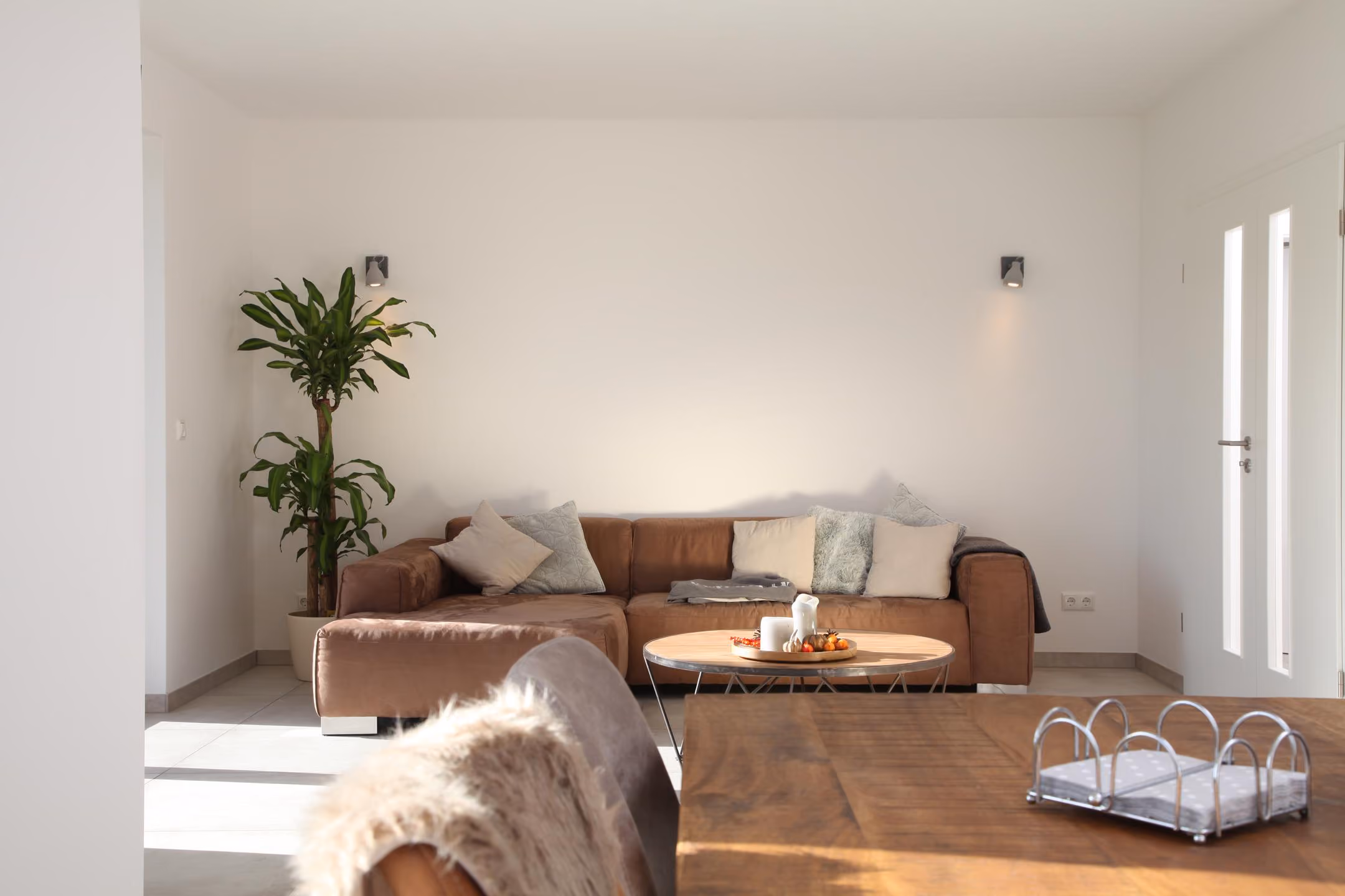 Wohnzimmer mit Ledersofa und heller Wand