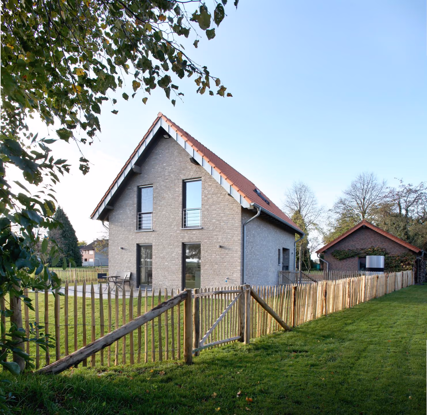 Gartenansicht mit Zaun und Nebengebäude