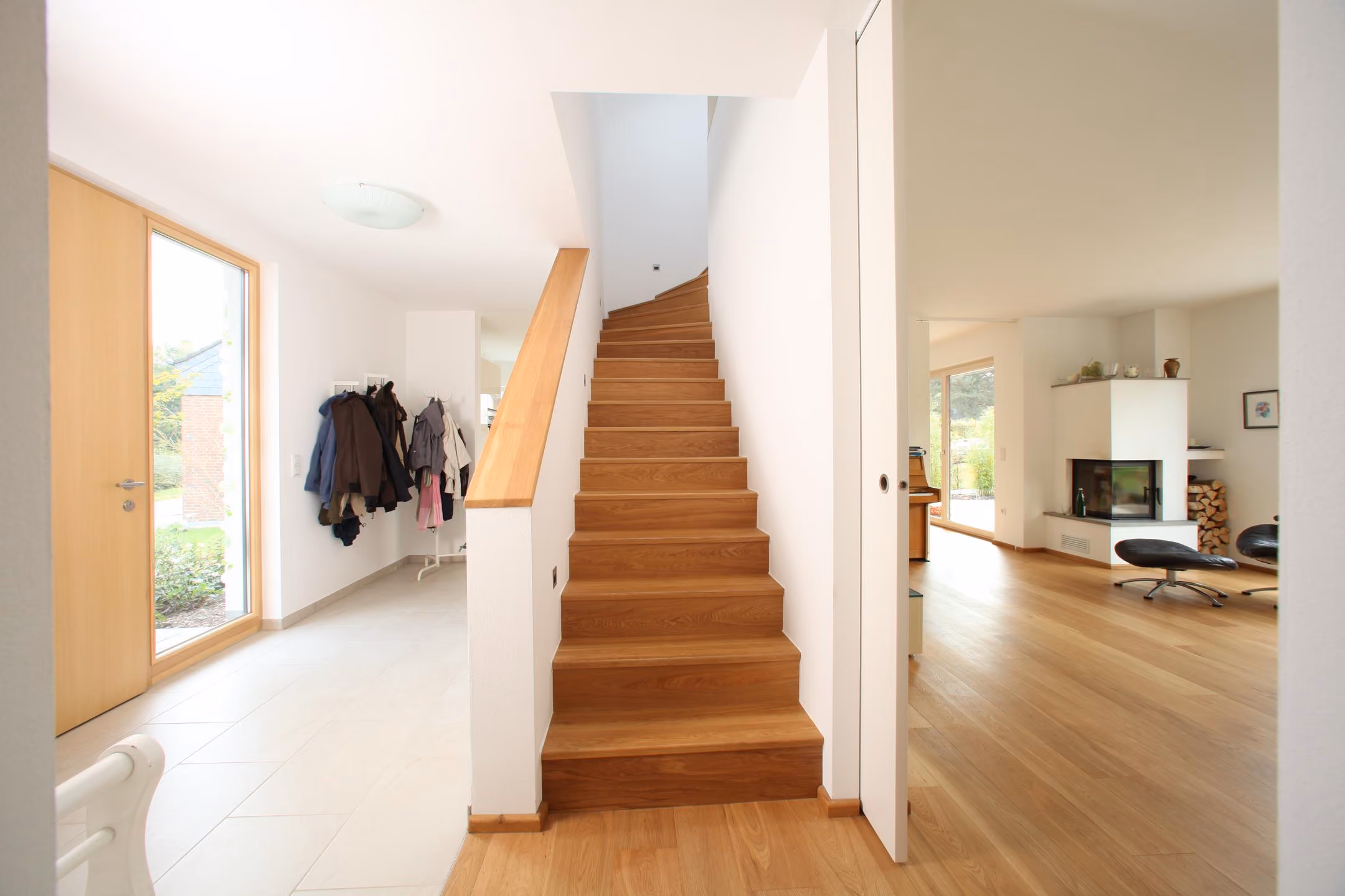 Eingangsdiele mit heller Holztreppe und Garderobe