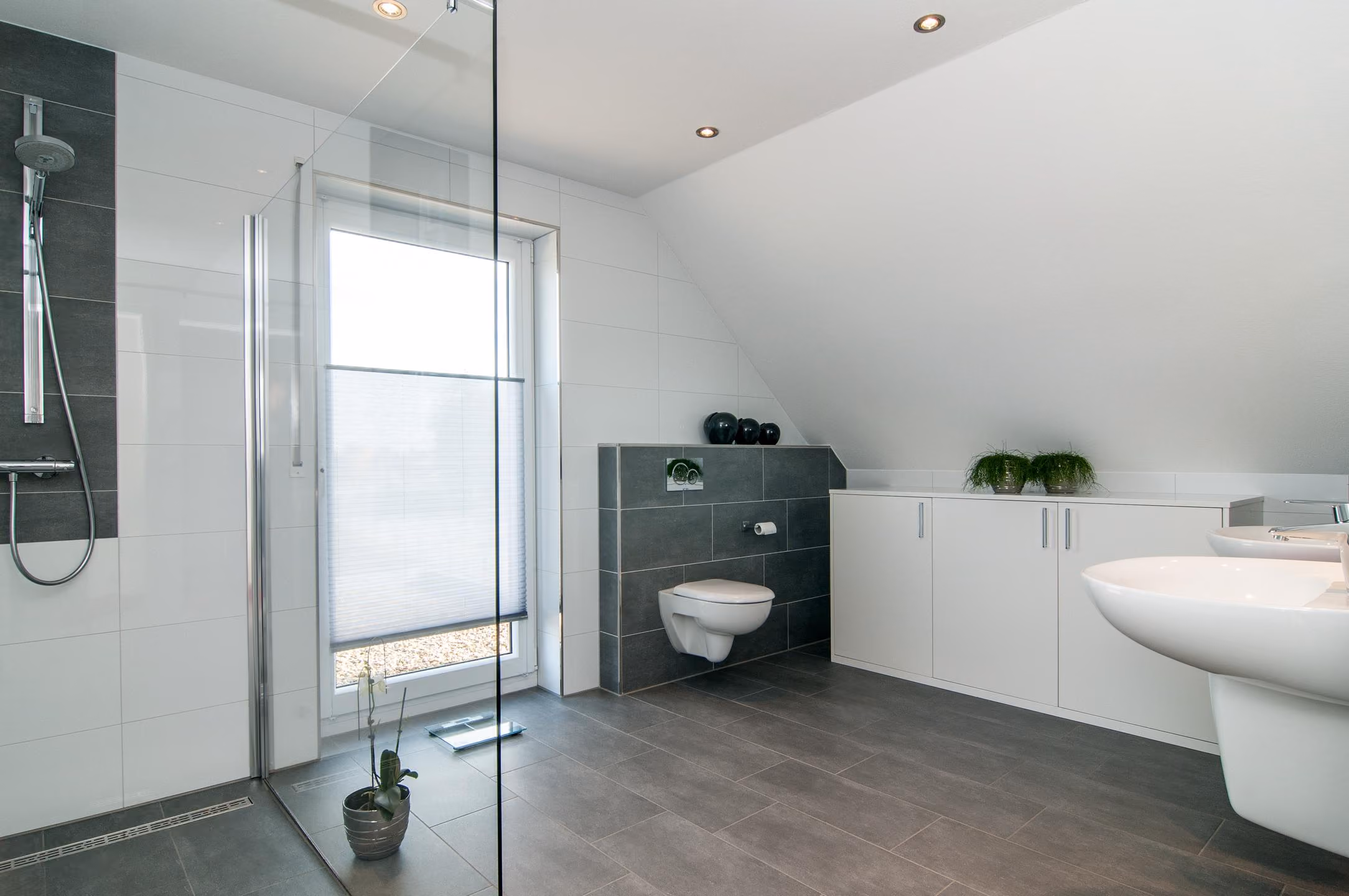 Badezimmer unter der Dachschräge mit bodentiefem Fenster