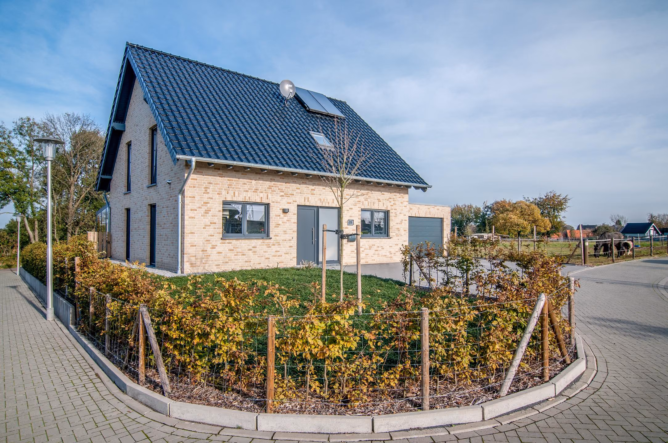 Hausansicht mit Garage und gepflastertem Vorplatz