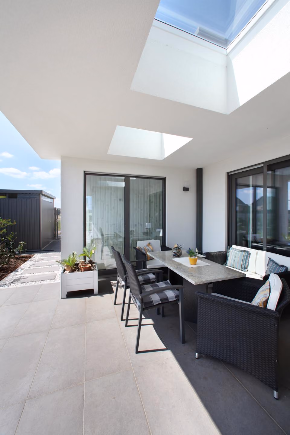 Terrasse mit Esstisch und großer Fensterfront