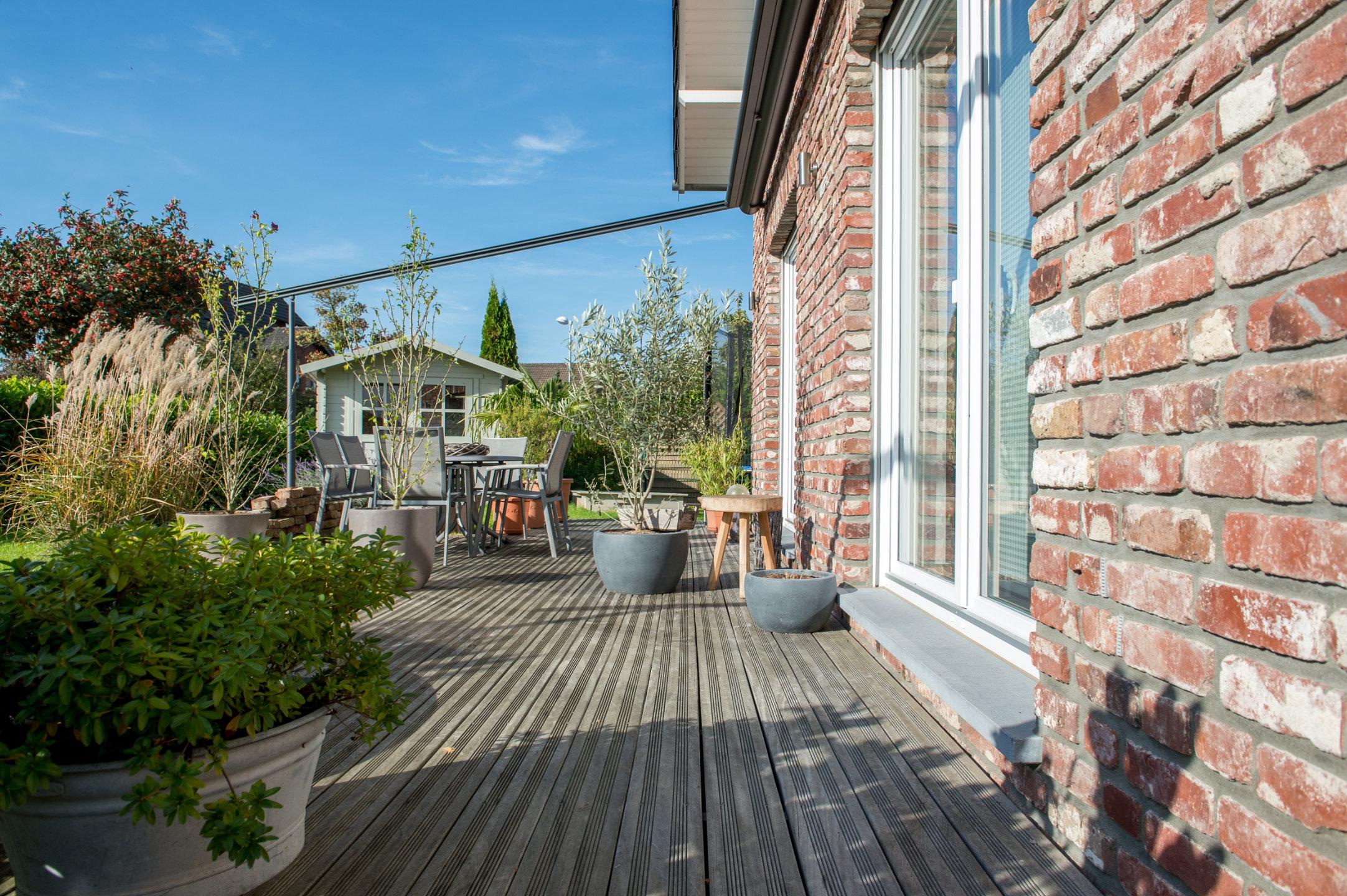 Terrasse mit Pflanzkübeln an der Klinkerwand