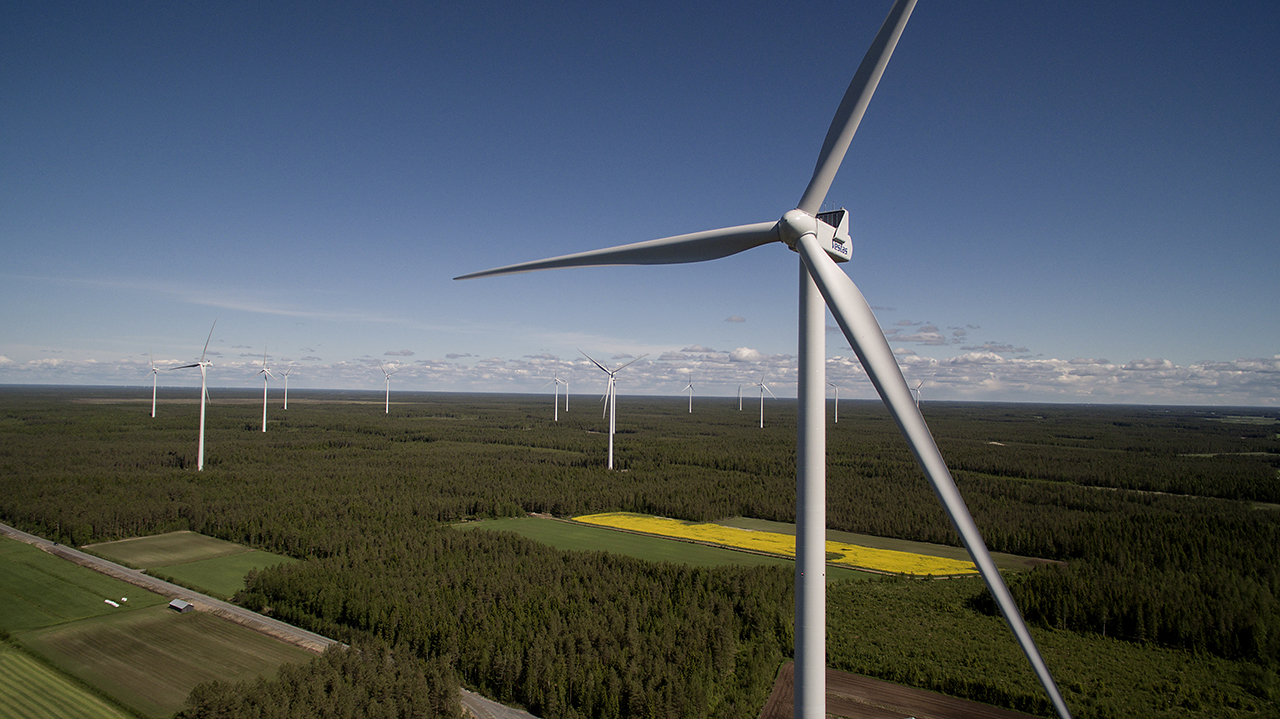 Sky view of several turbines in a woodland landscape